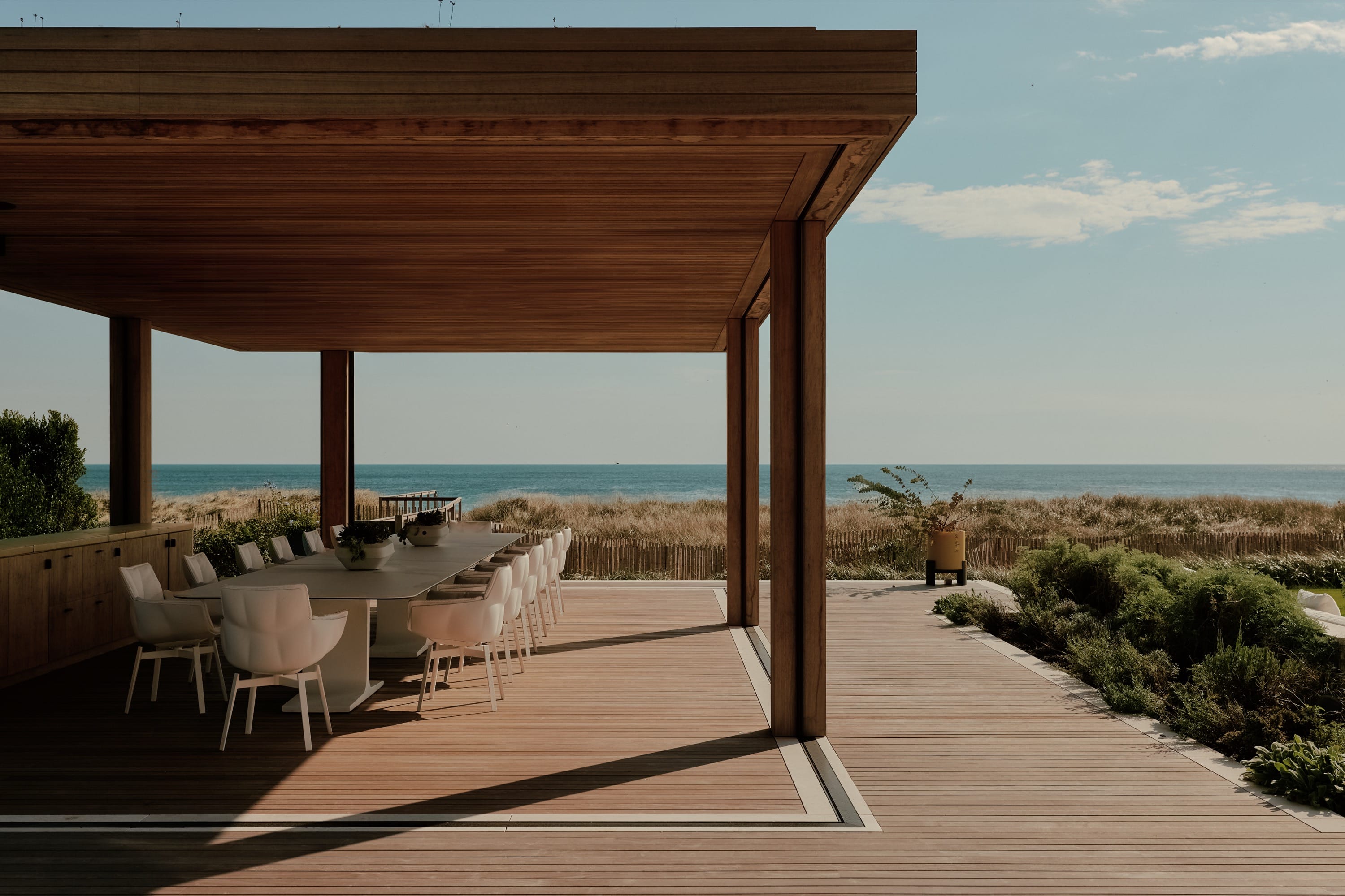 Covered patio with seating and ocean view.