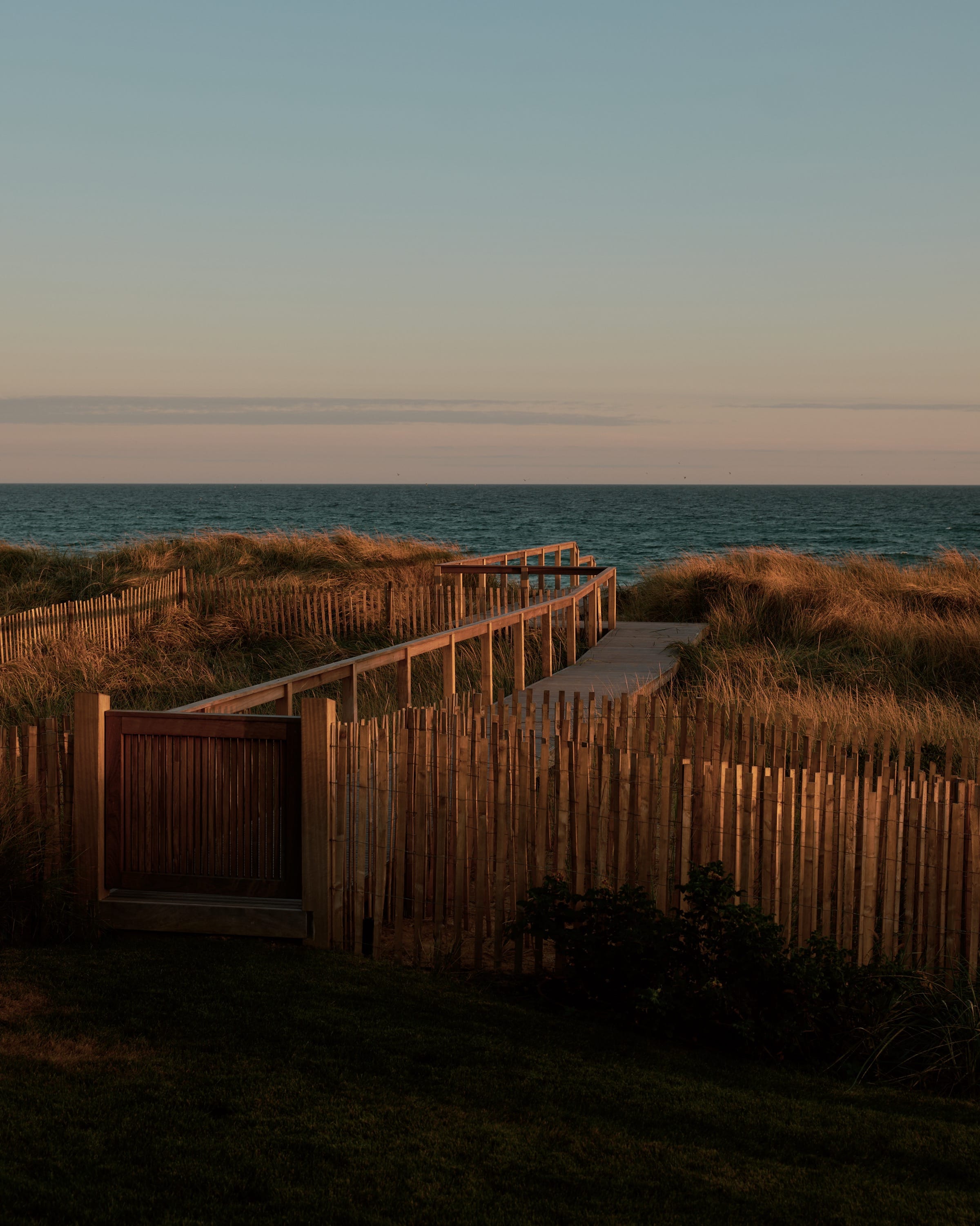 Boardwalk leading to beach at sunset.