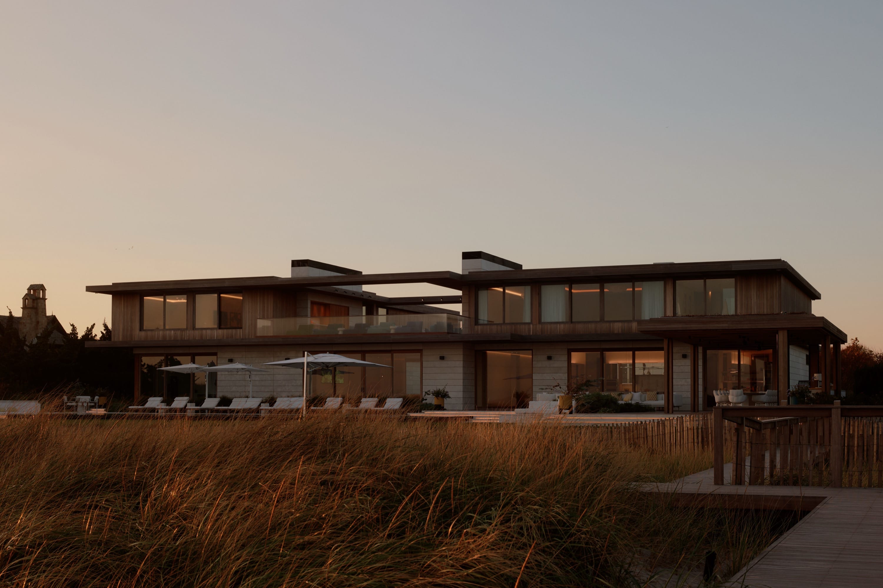 Modern home with pool and evening sky.