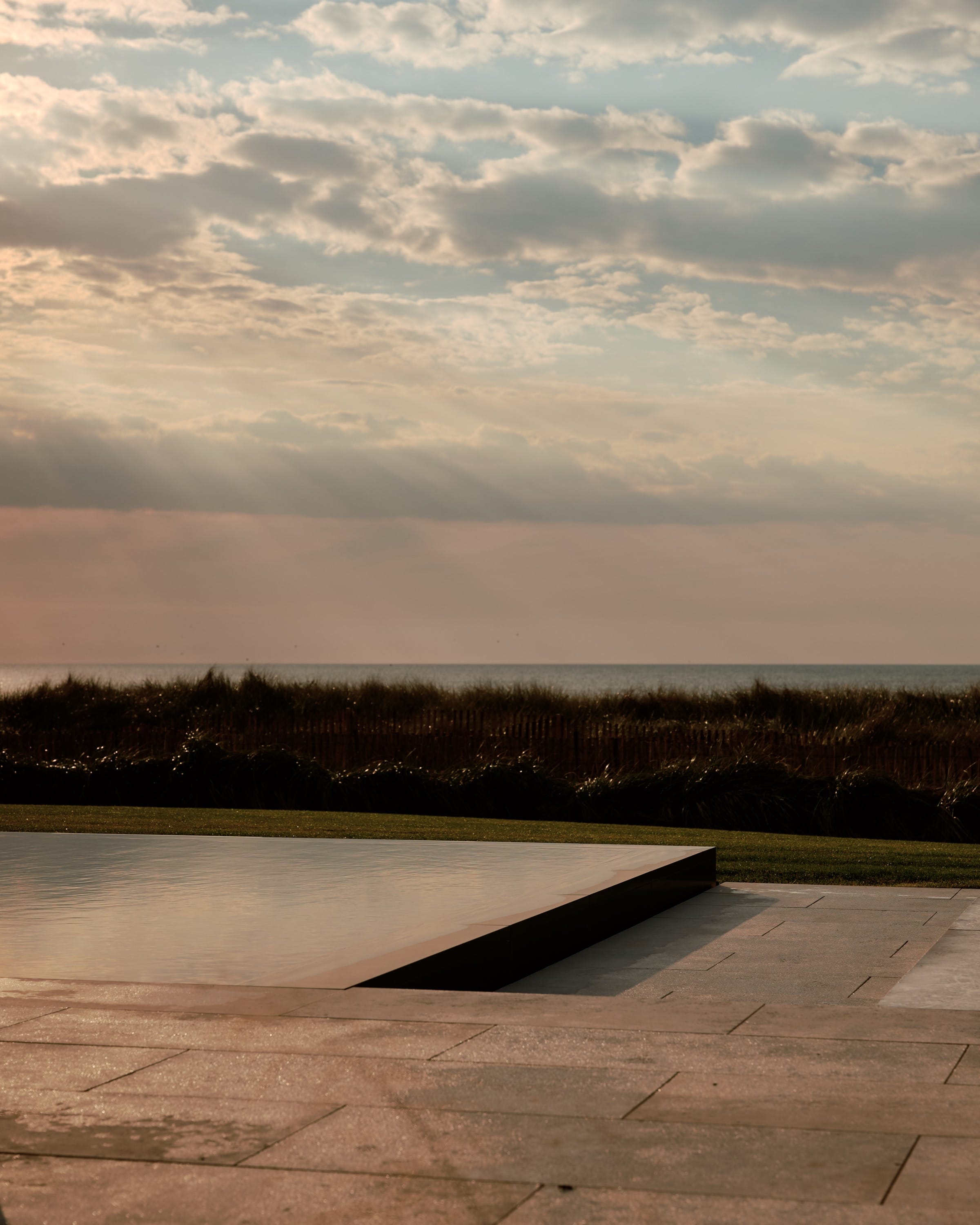 Infinity pool overlooking ocean at sunset.