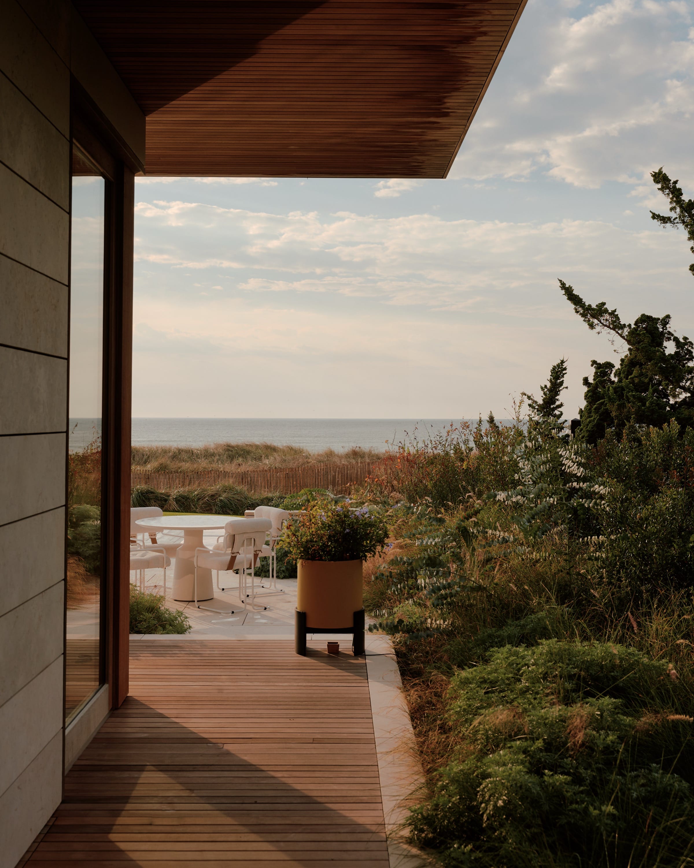 Wood deck with ocean view and greenery.