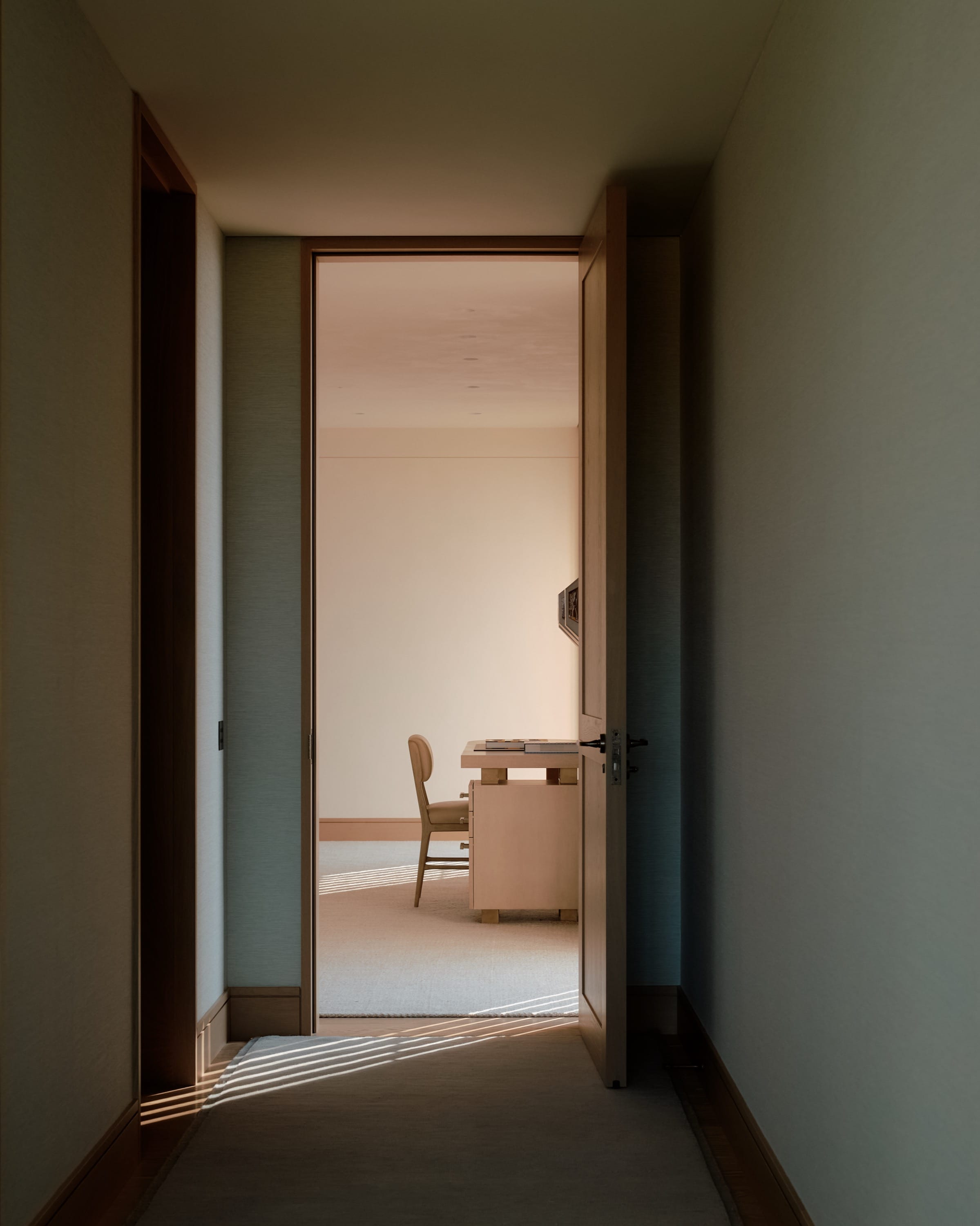 Hallway leading to living space with natural light.