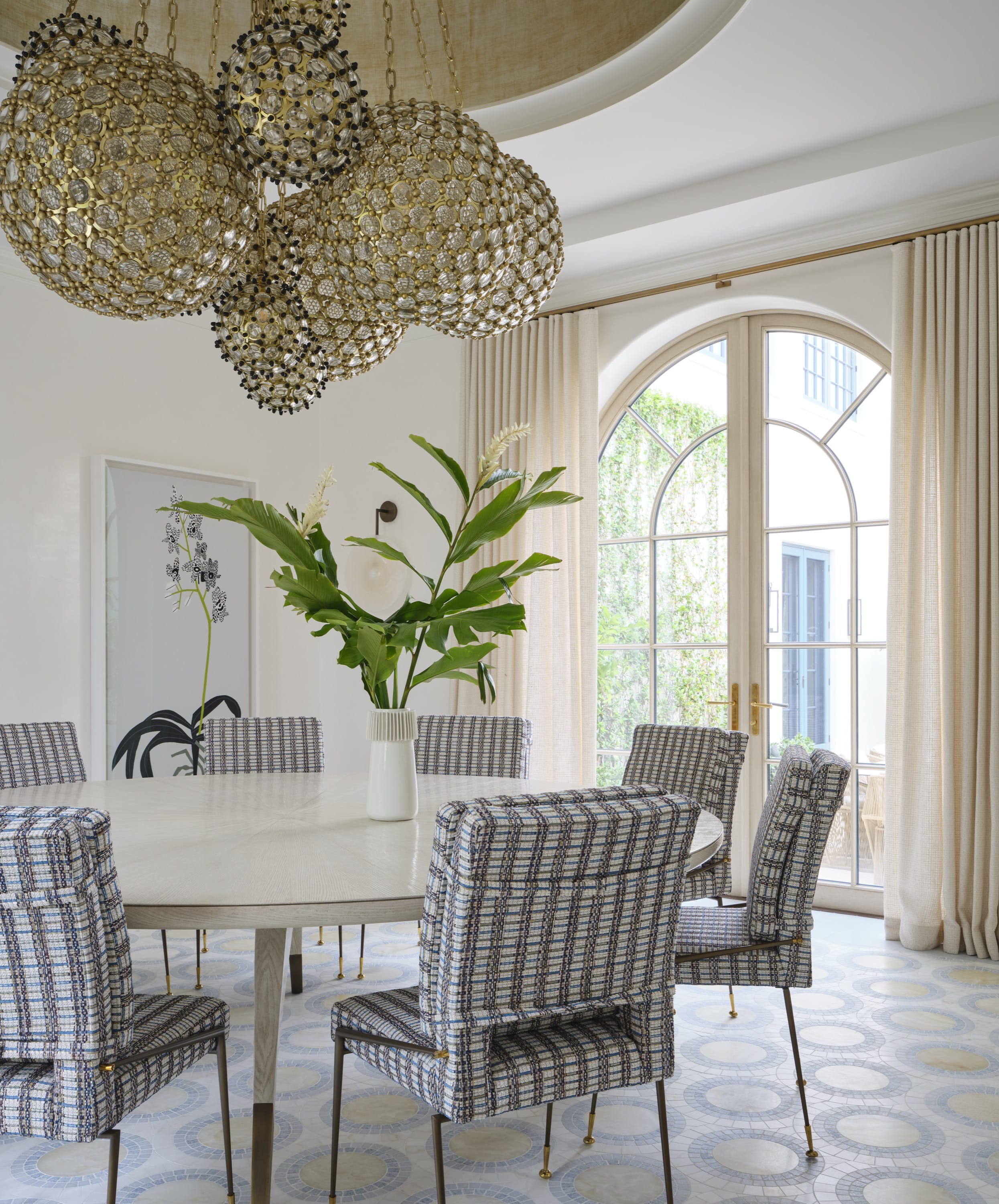Dining area with striped chairs and tall windows.