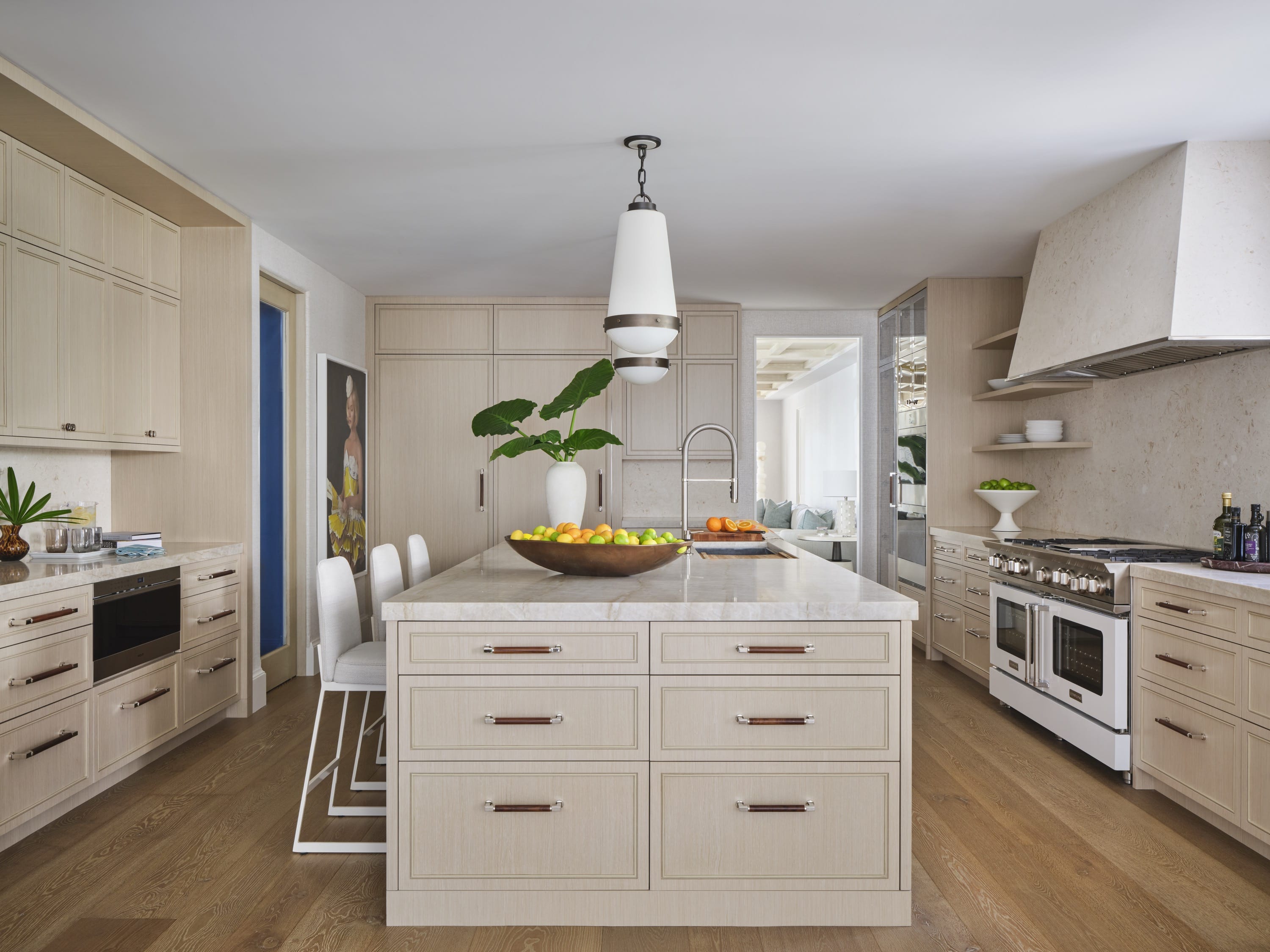 Kitchen with large white island and pendant lights.