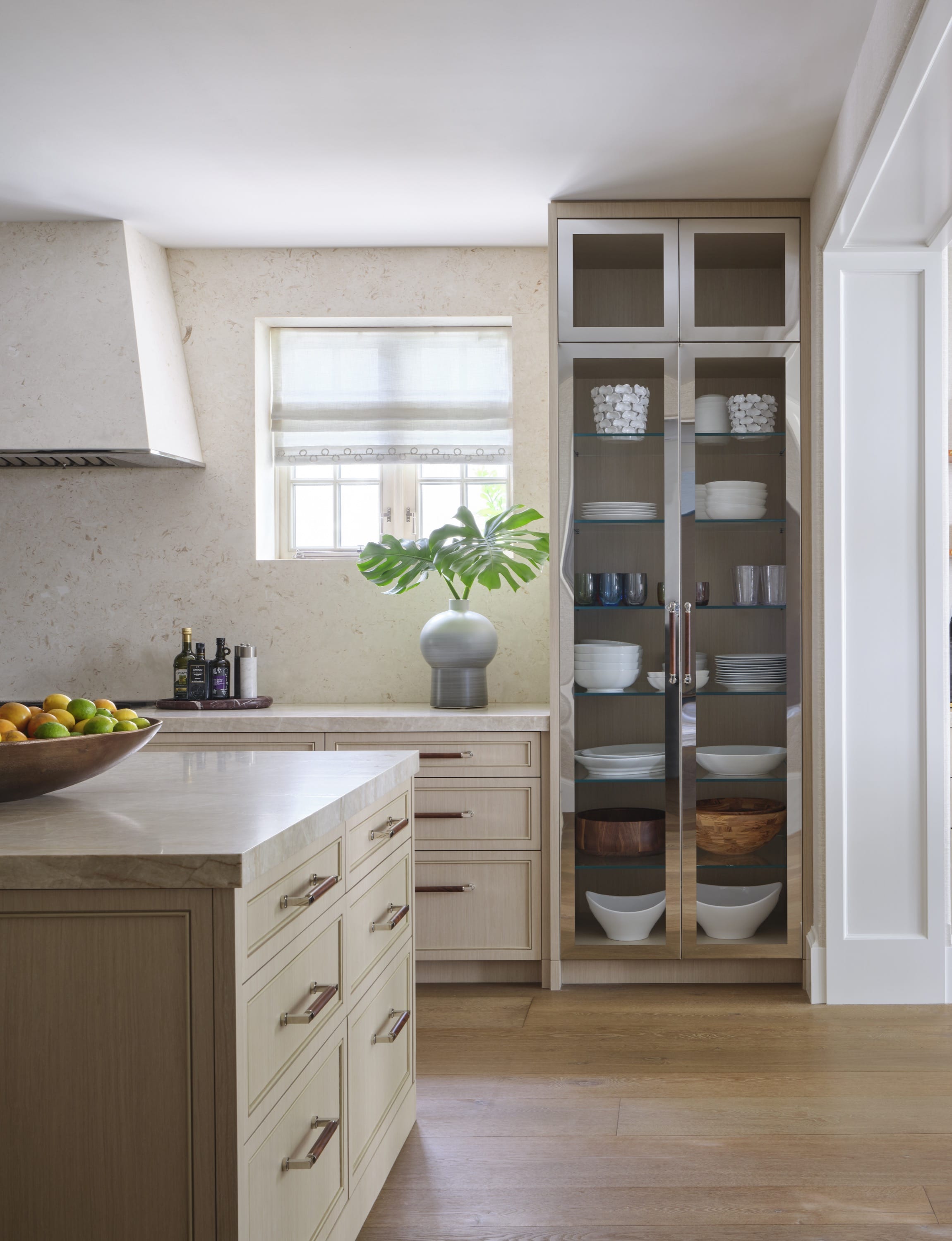 Kitchen with island, open shelving, and stainless appliances.