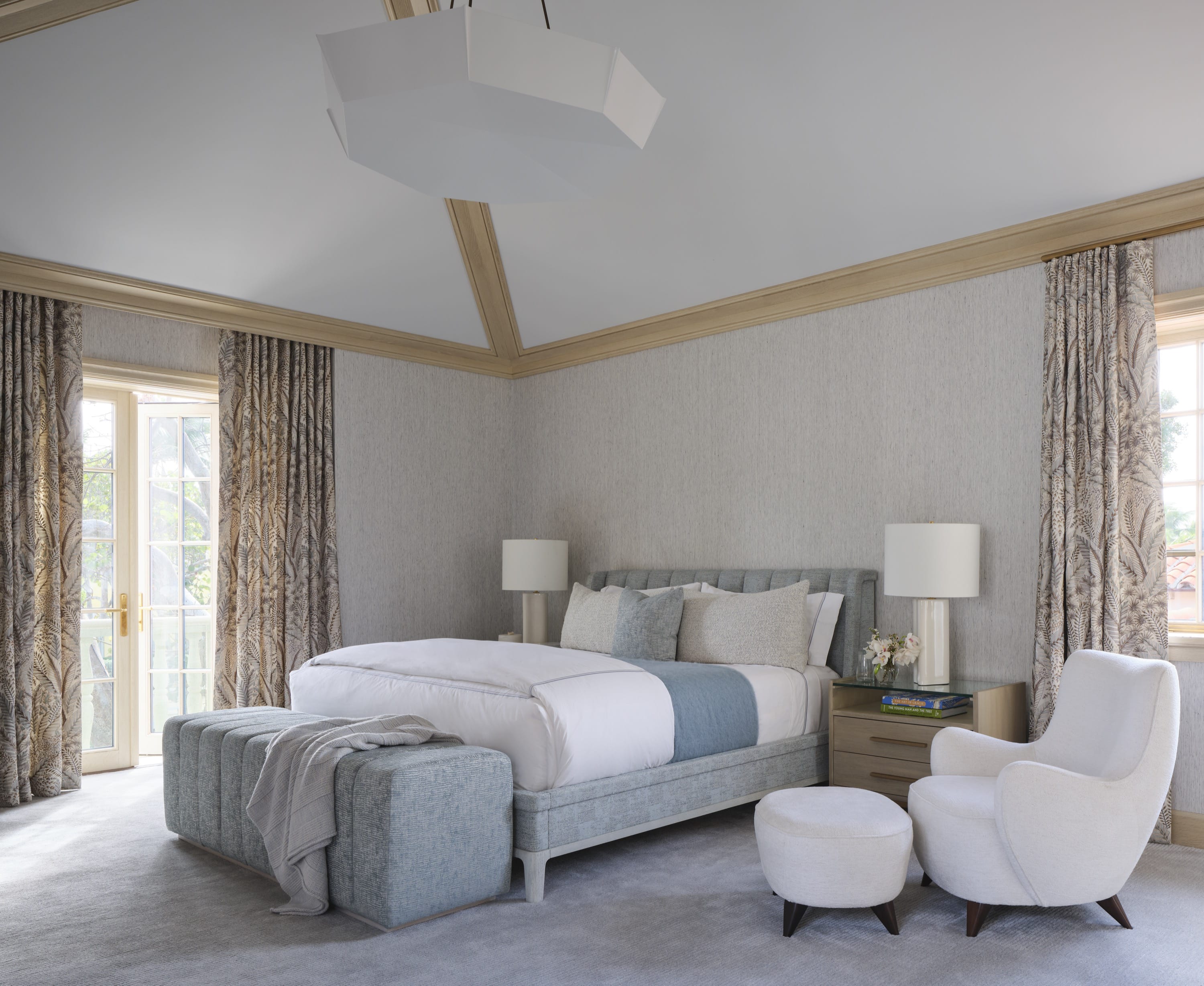 Bedroom with seating nook, chandelier, and neutral tones.