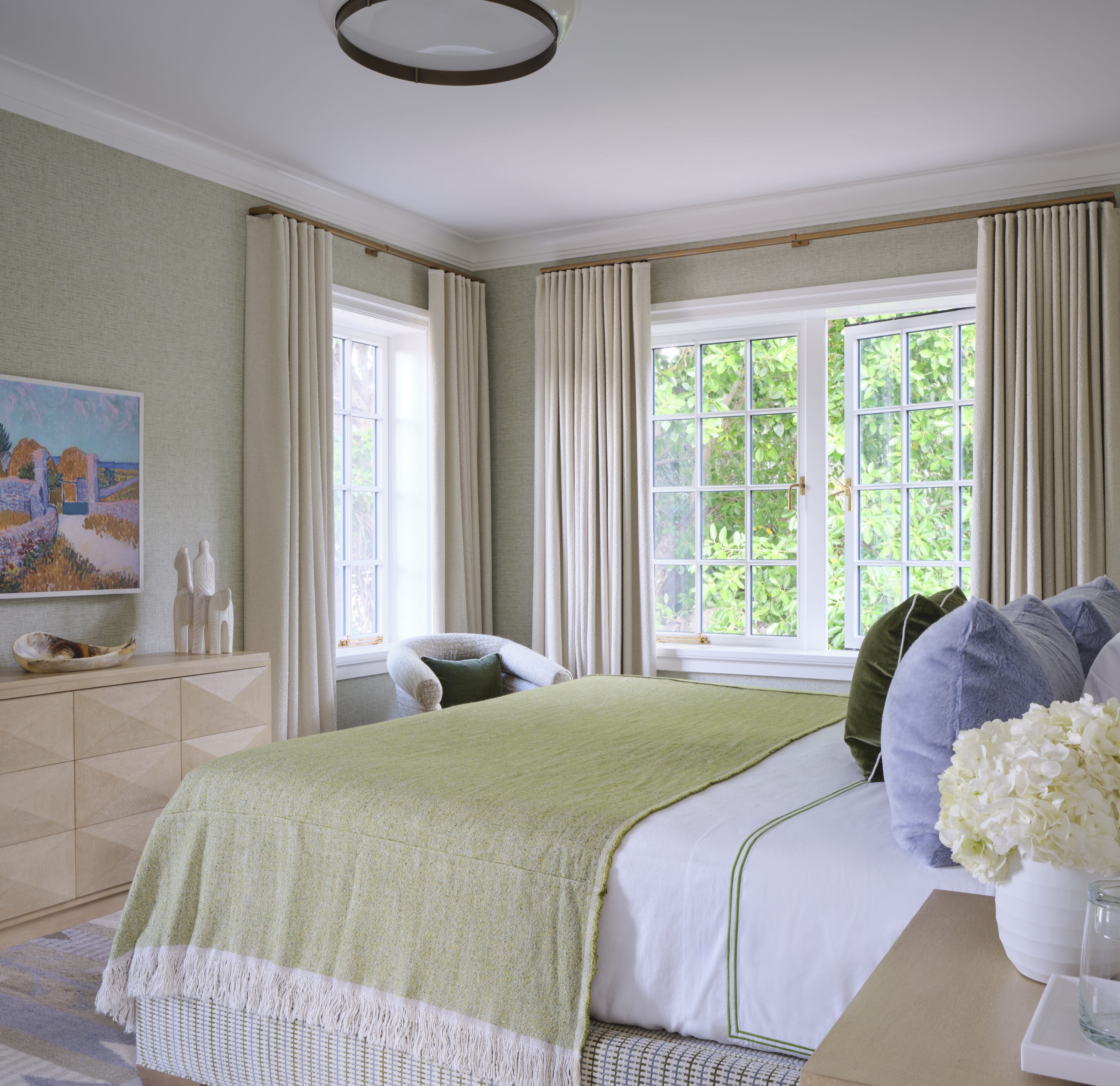Bedroom with green accents, bench, and wood nightstands.
