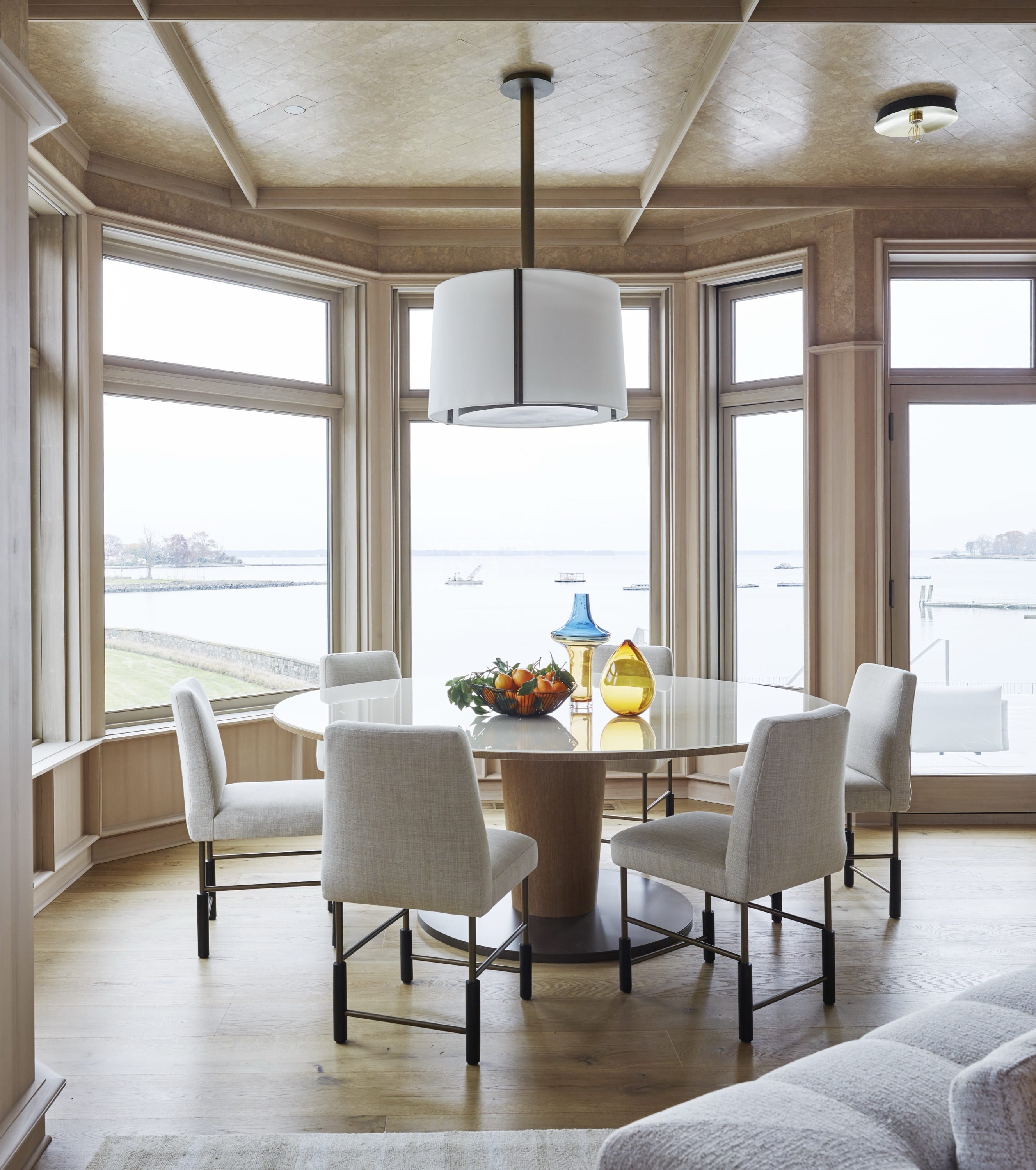 Breakfast nook with round table and bay windows.