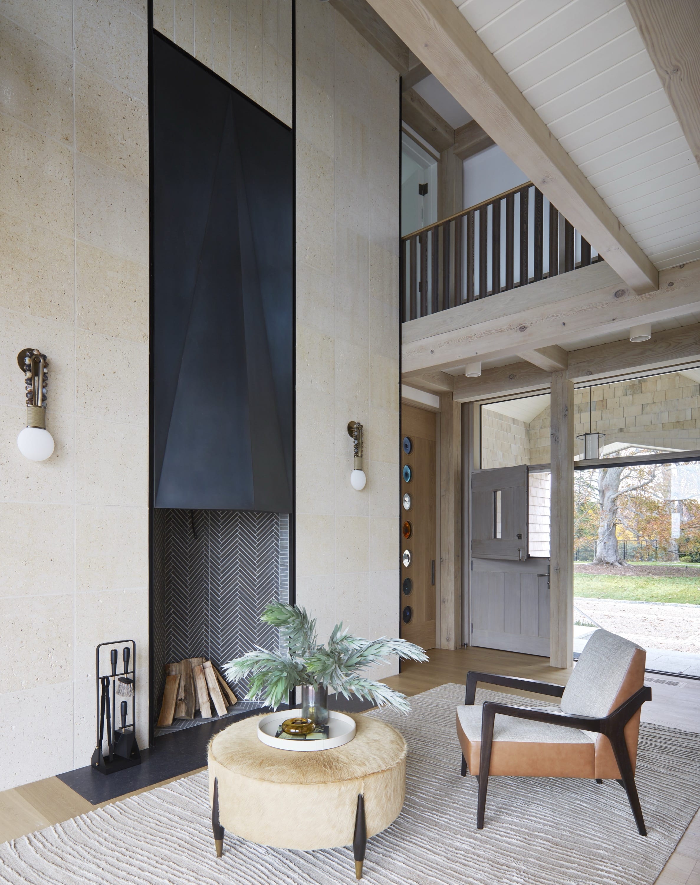 Two-story living room with exposed beams and tall windows.