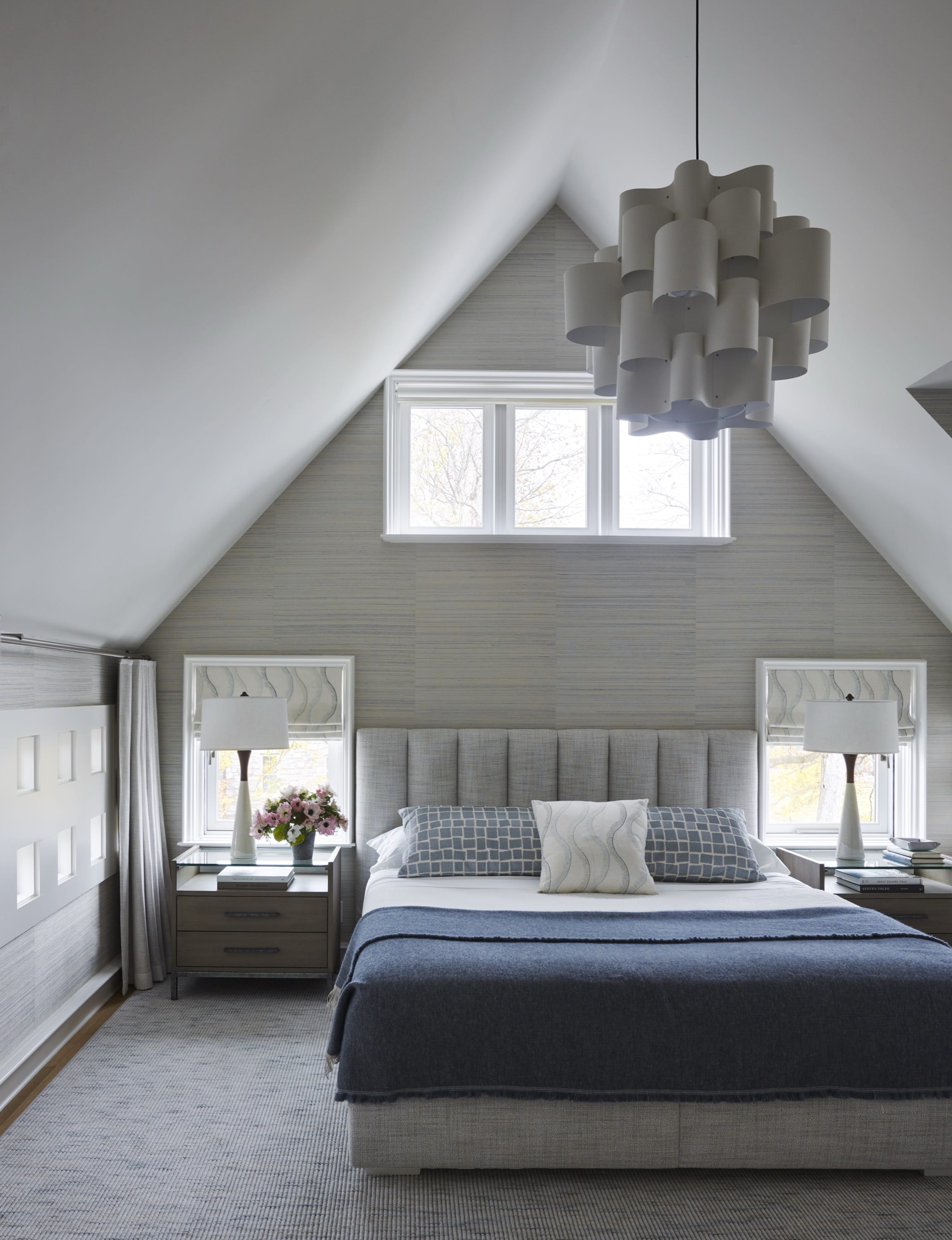 Bedroom with vaulted ceiling and modern chandelier.