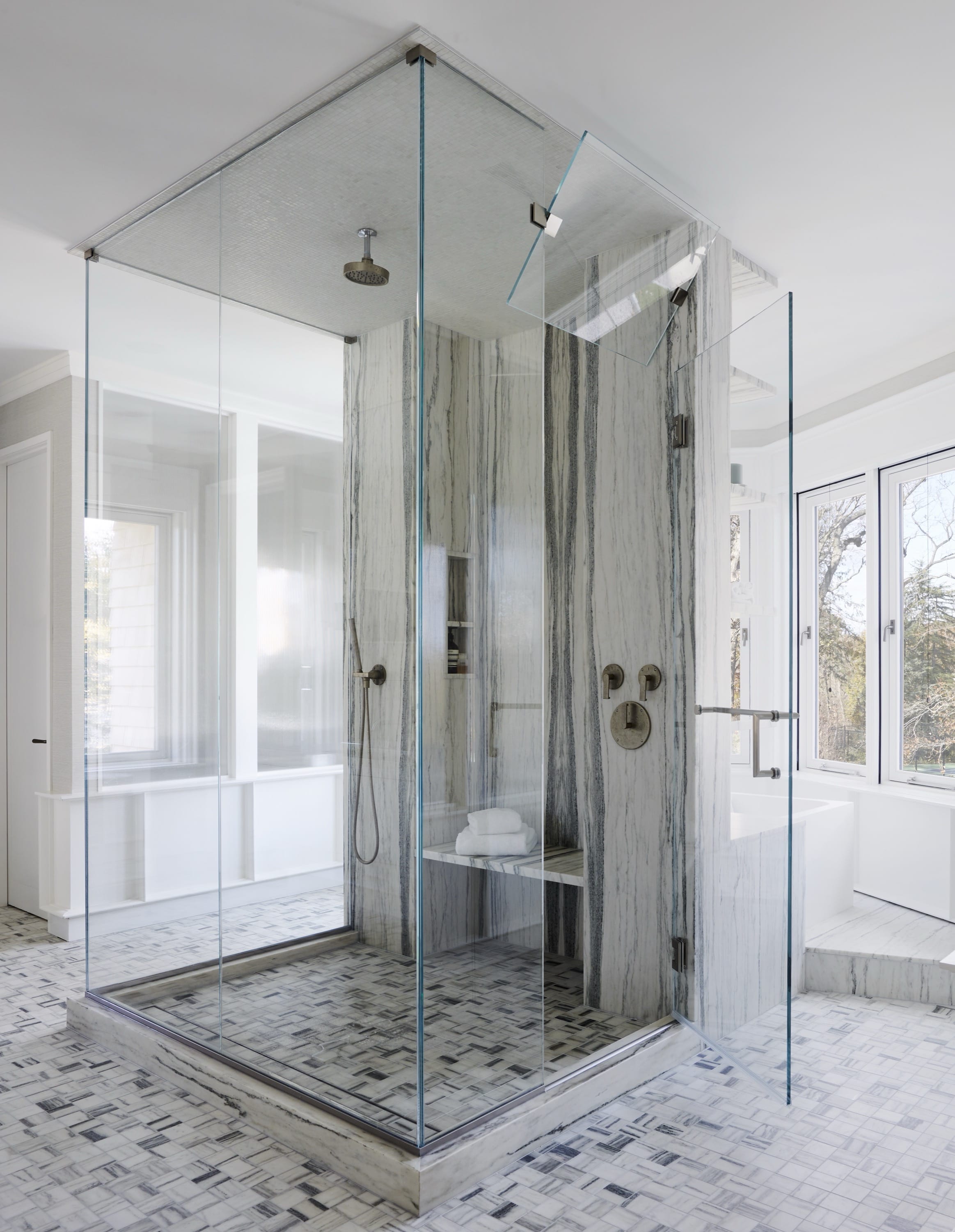 Bathroom with marble shower and glass enclosure.