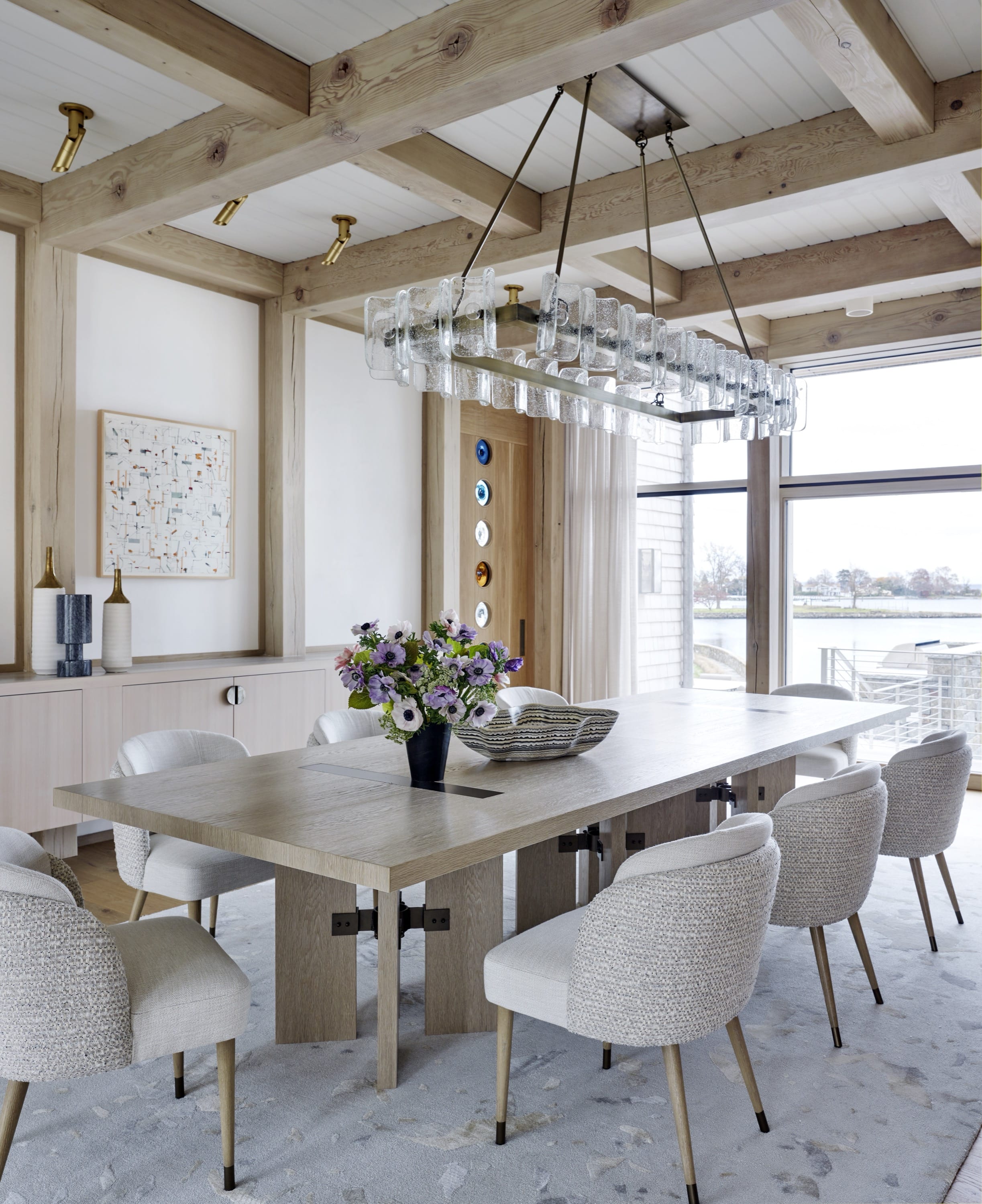 Dining room with long white table and chandelier.