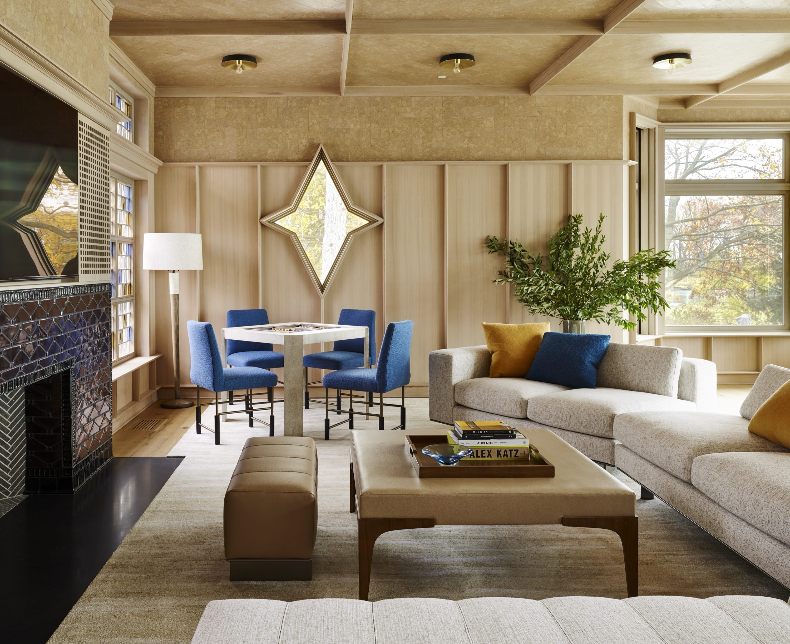 Living room with wood paneling and blue chairs.