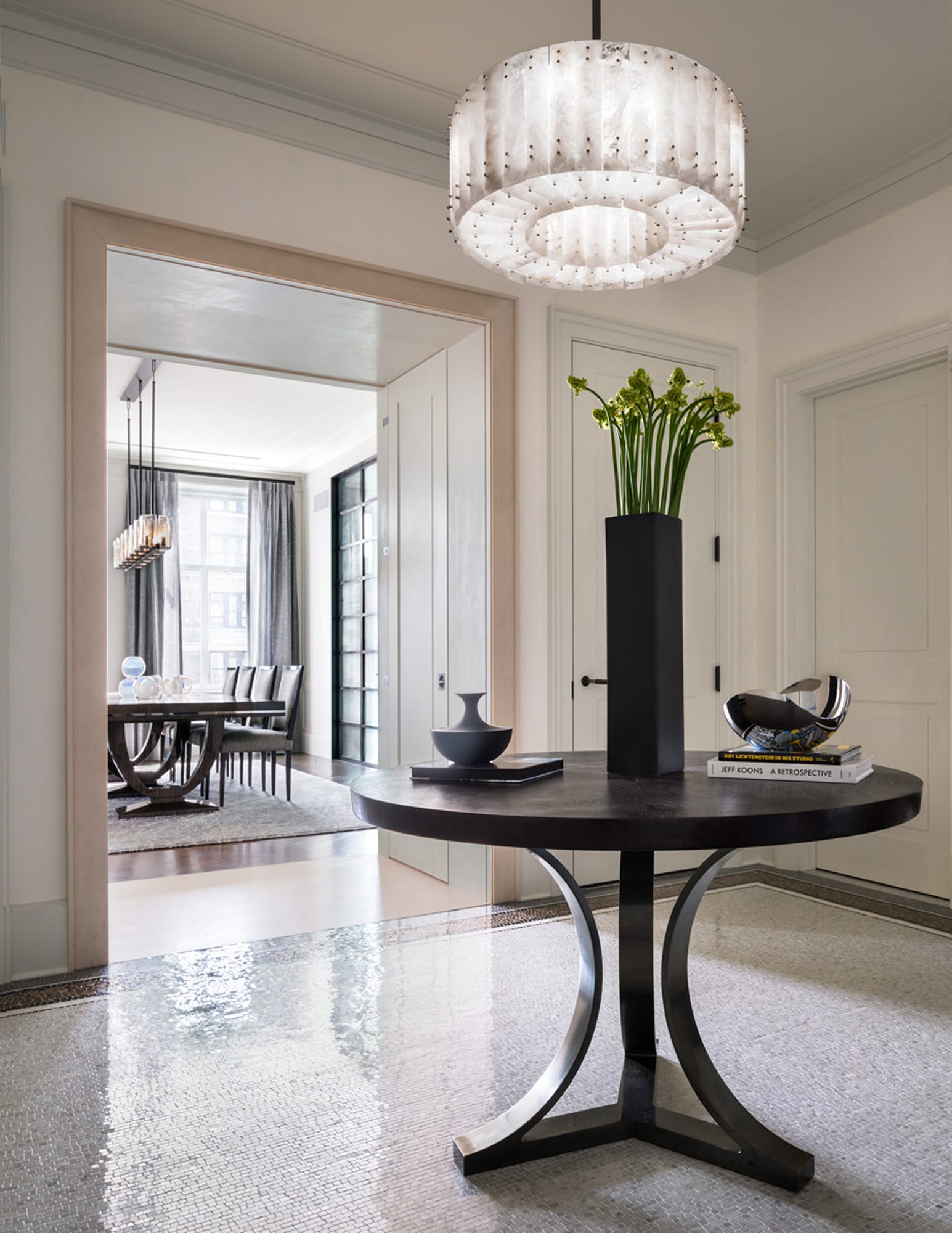 Elegant entryway with round table and chandelier.