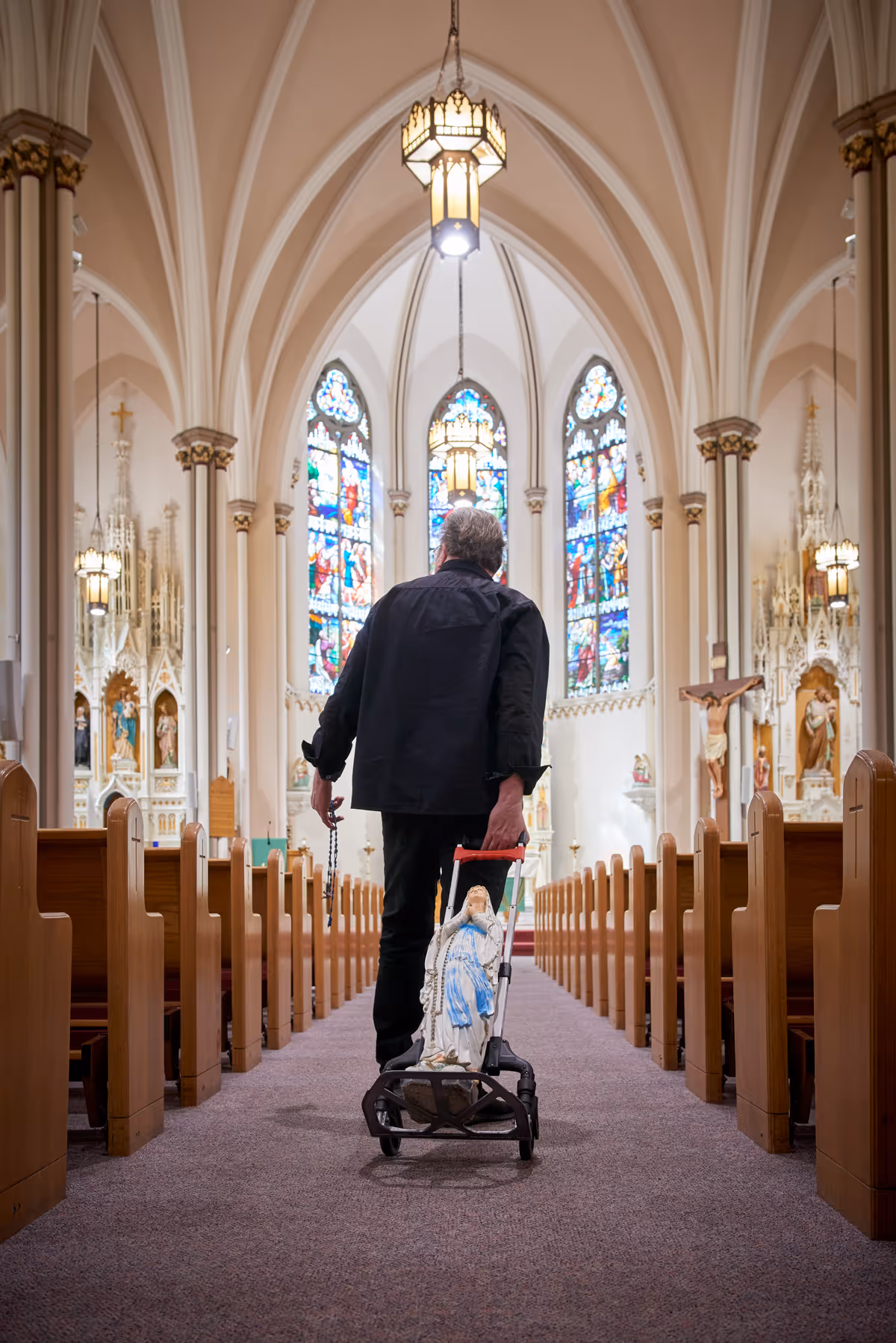 Kevin Matthews wheeling in the broken Mary statue into a church