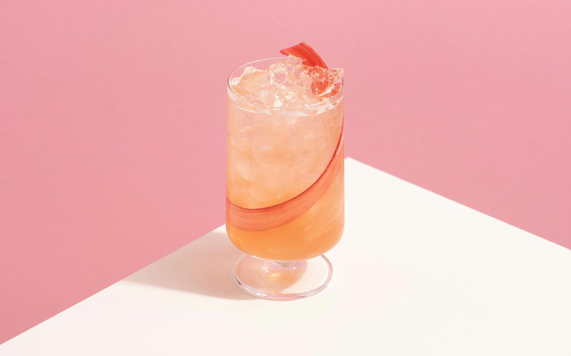 A glass of cocktail is standing on the table.
