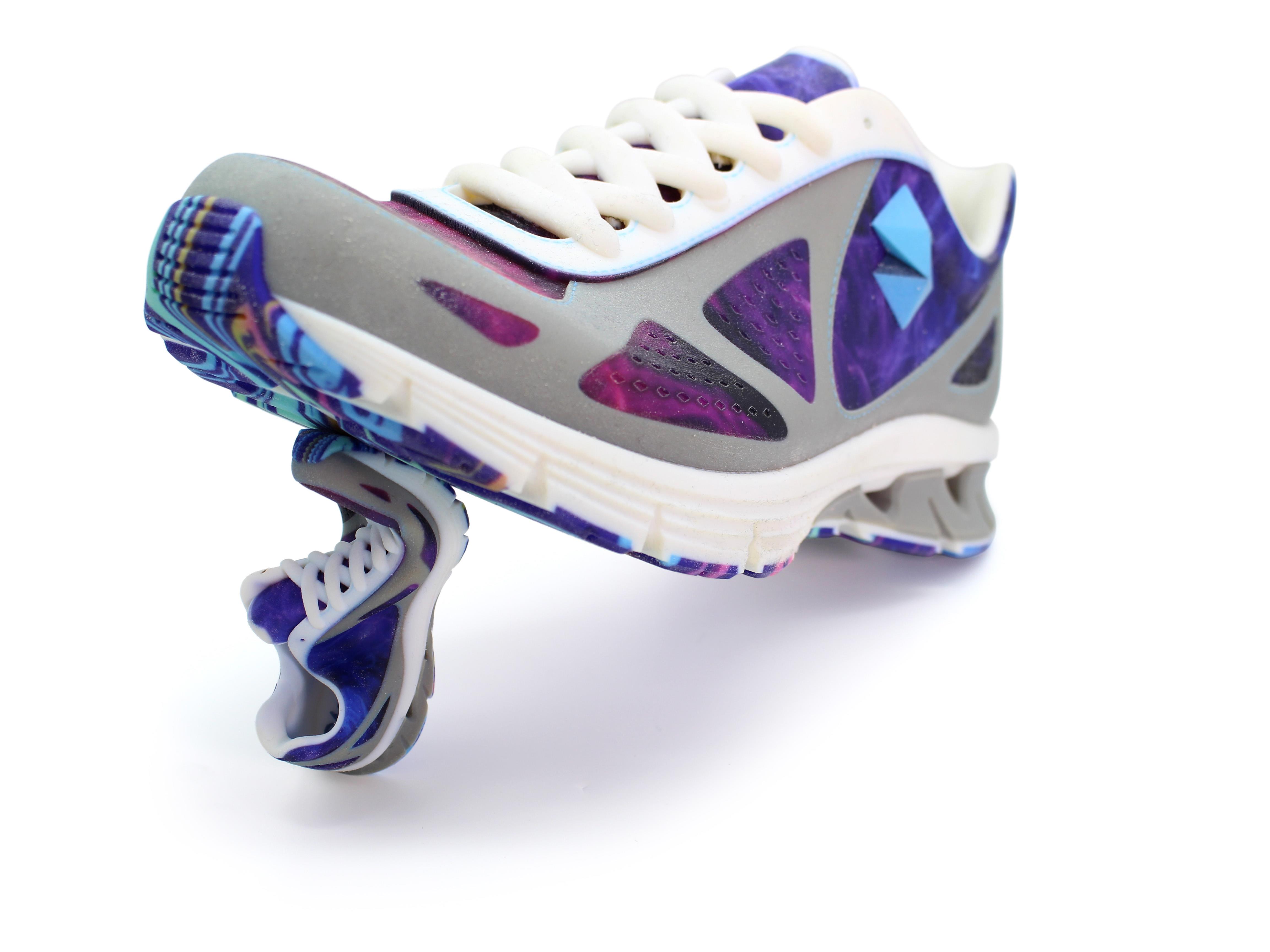Large sneaker balancing on a smaller, bent sneaker with purple, gray, and white colors on a white background.