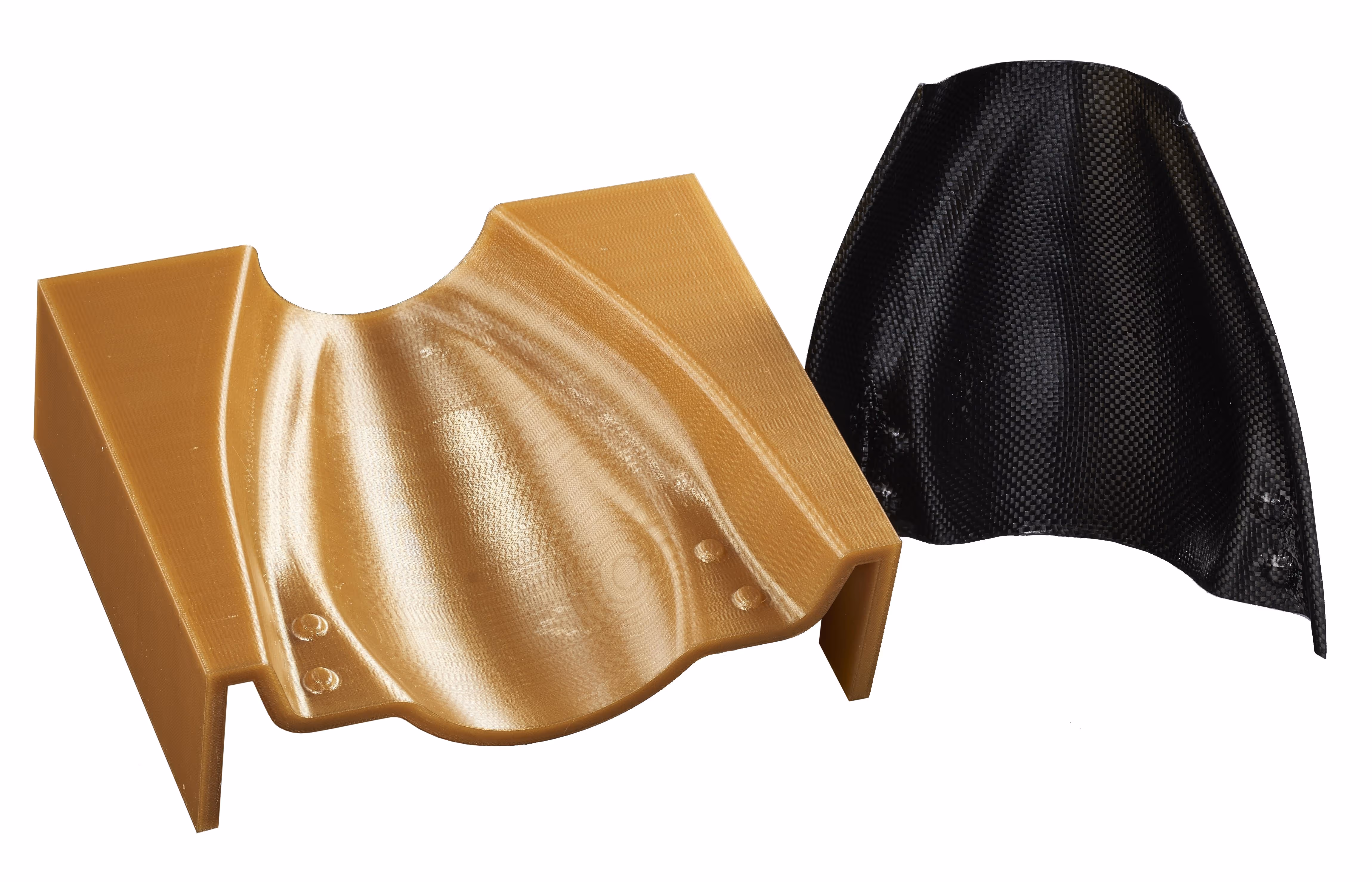 Two industrial molded parts, one in tan plastic and one in black carbon fiber, with curved shapes and mounting holes.