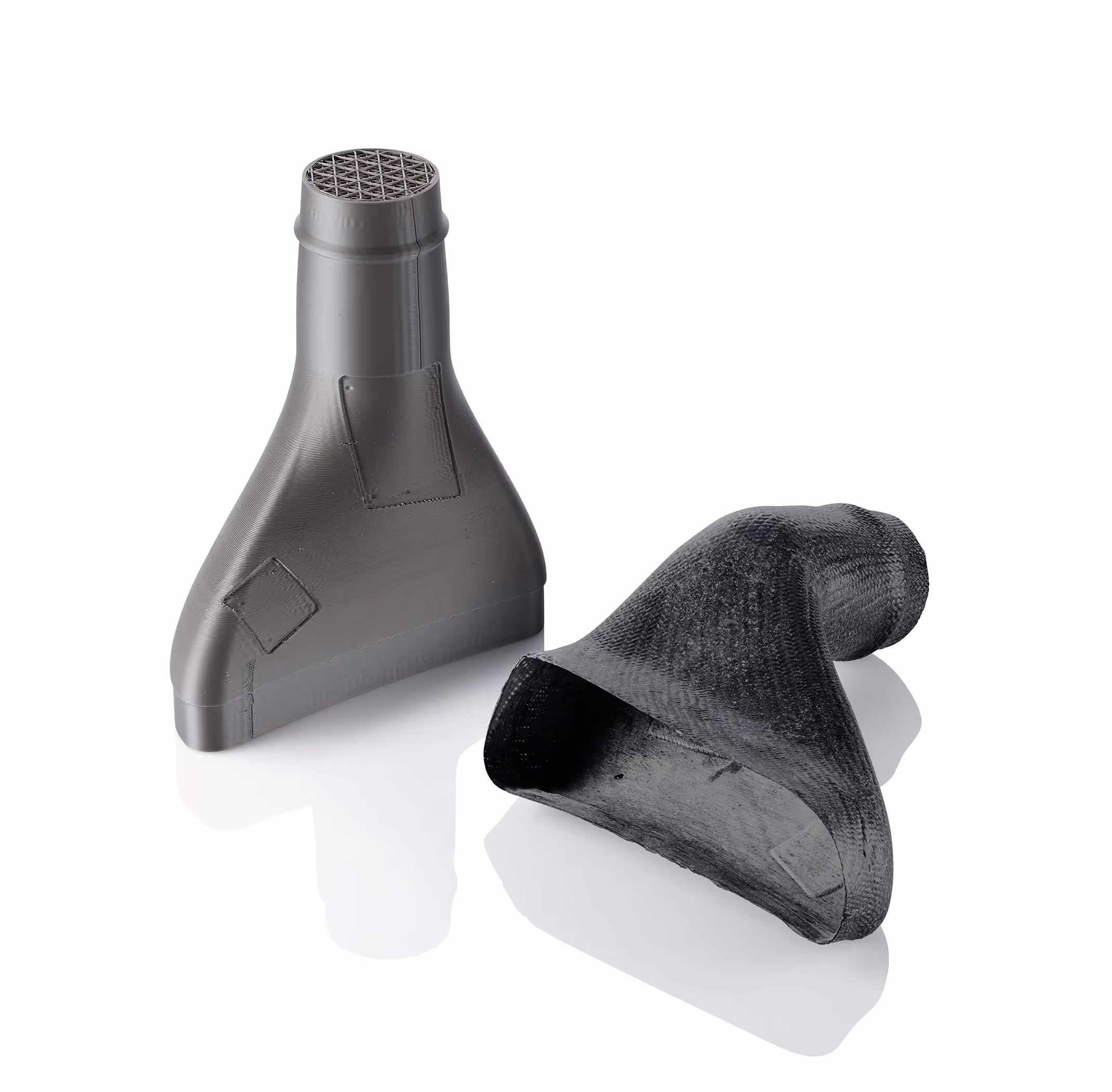 Two black 3D-printed funnel-shaped objects on a white reflective surface.