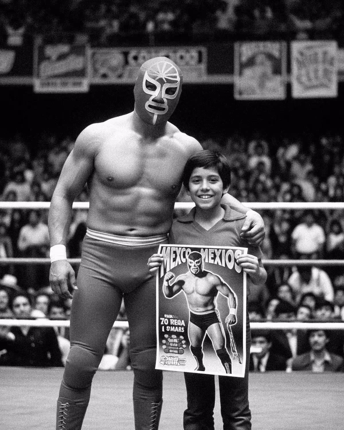 Vintage photo of the luchador Yoyoman in the ring with a young fan holding his poster. Historic black and white photo for Tacos Yoyo in Miami.