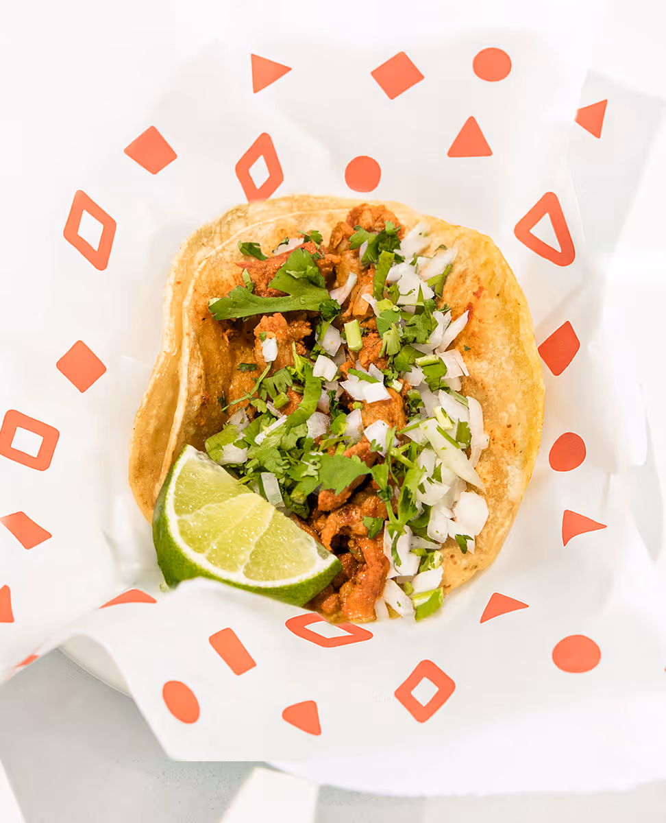 Mexican street taco with al pastor meat, onions, cilantro, and lime on a corn tortilla, served at Tacos Yoyo in Miami.