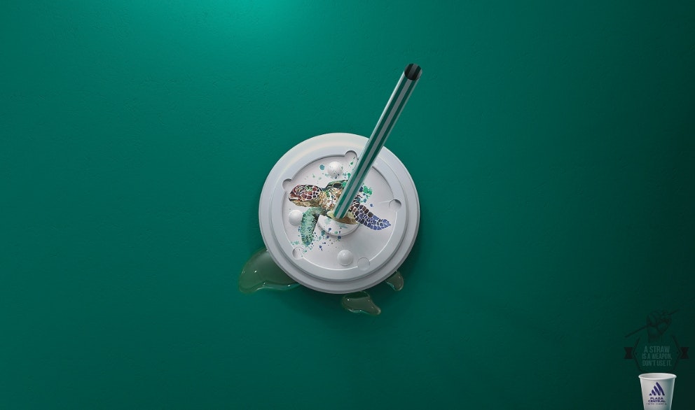 Straw sticking out of plastic lid with turtle underneath