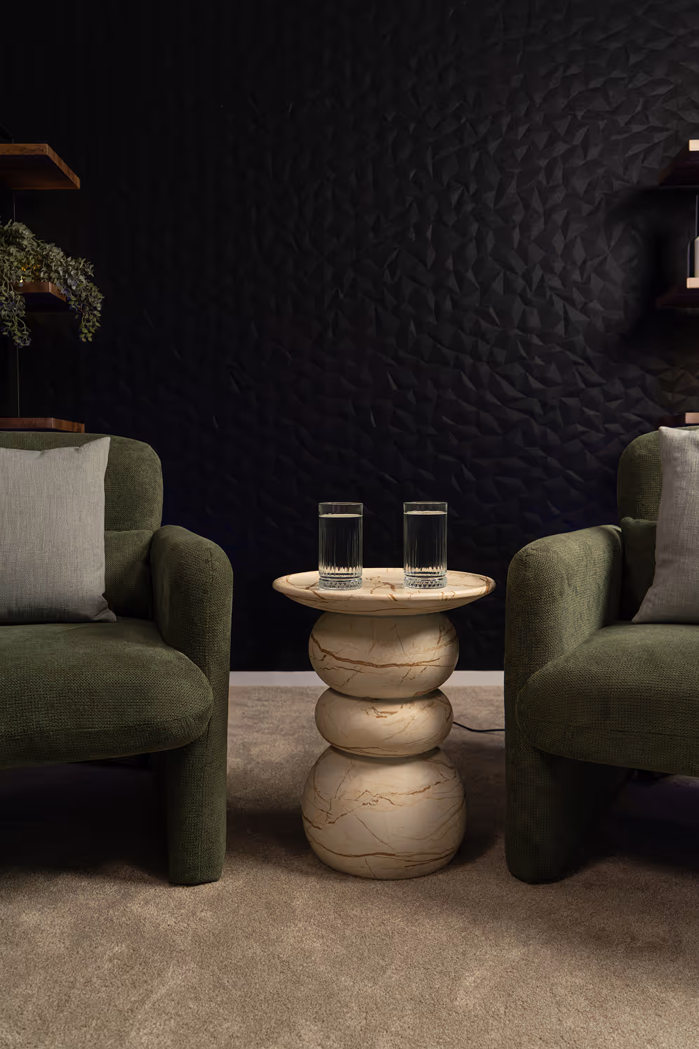 A dark scheme podcasting studio with green chairs & a stone side table
