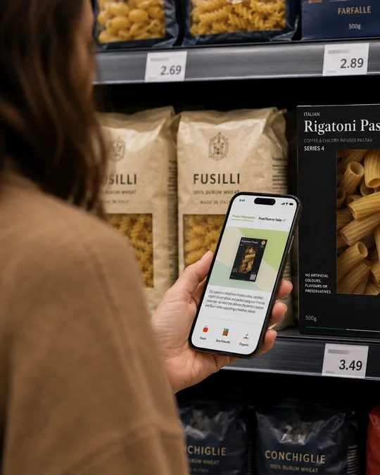 A shopper scanning a home brand pasta pack on the shelf with her phone