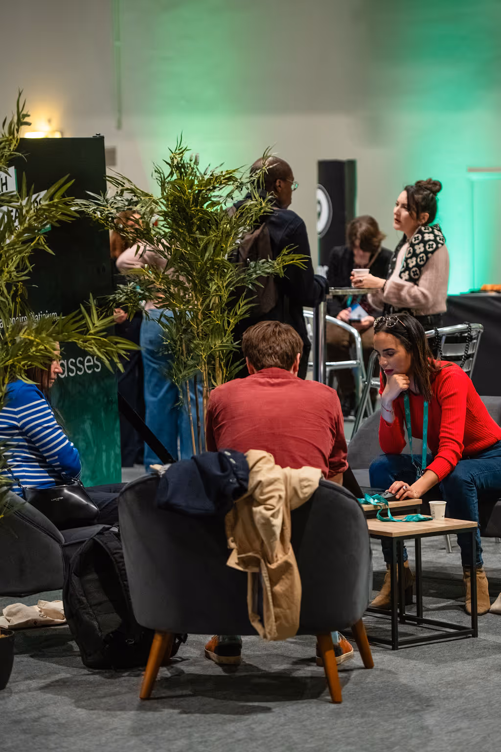 People sitting and standing at a social event, talking and networking in a relaxed atmosphere.