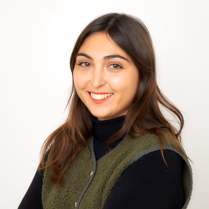 A person is smiling at the camera against a plain white background.