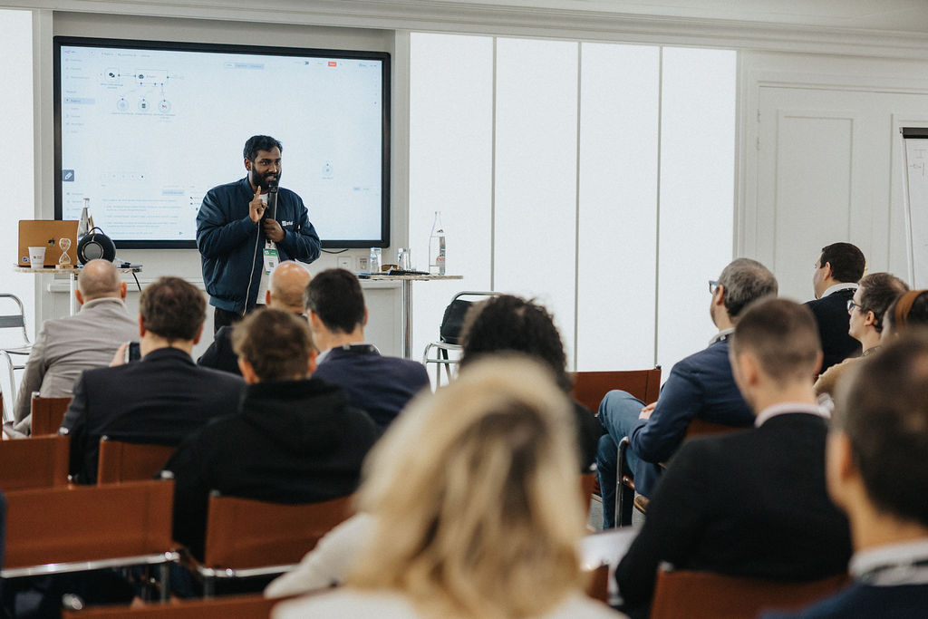 A man is speaking in front of an audience at a conference or meeting.