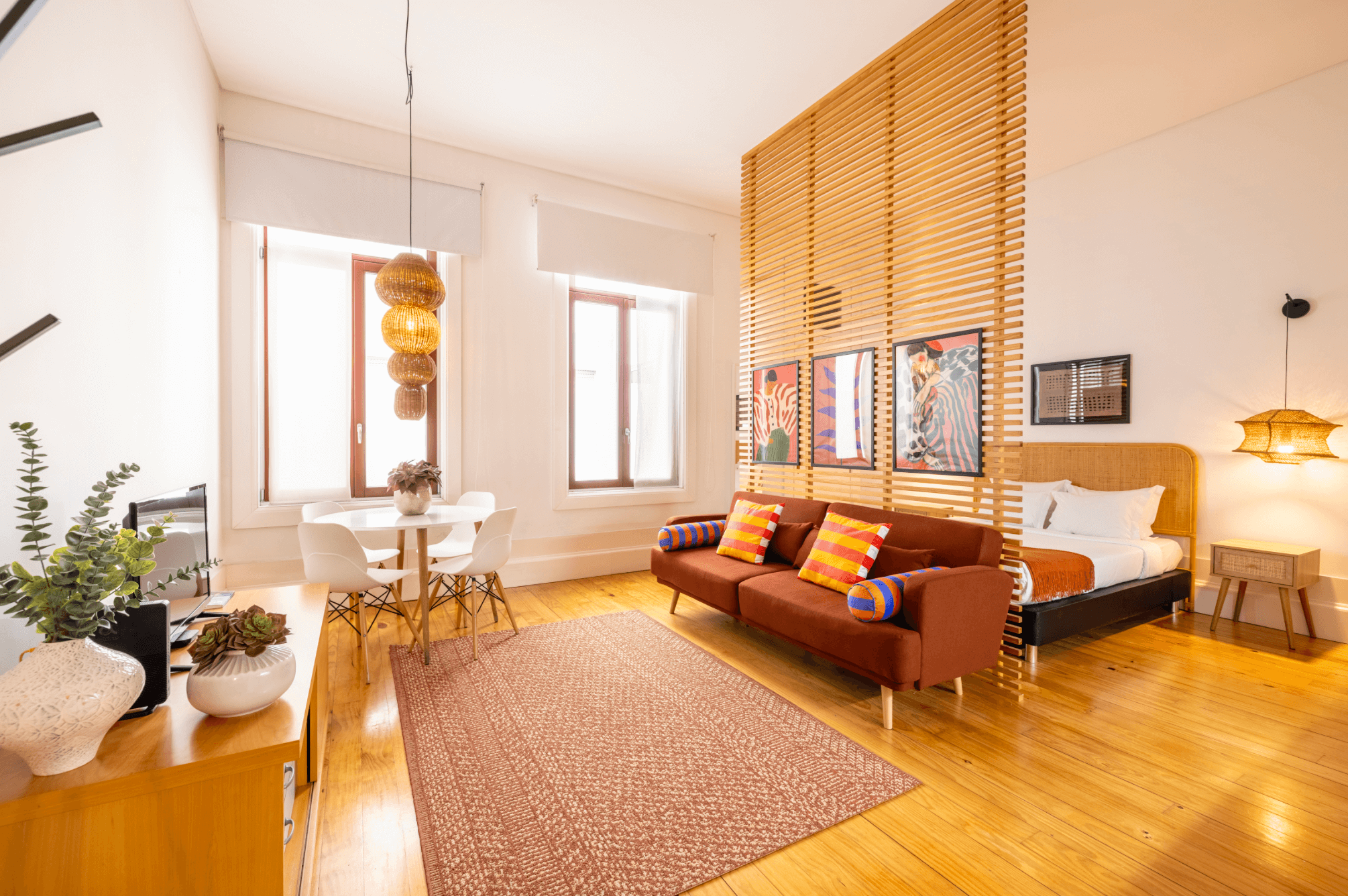 Interior with a bed and a sofa with colorful pillows.