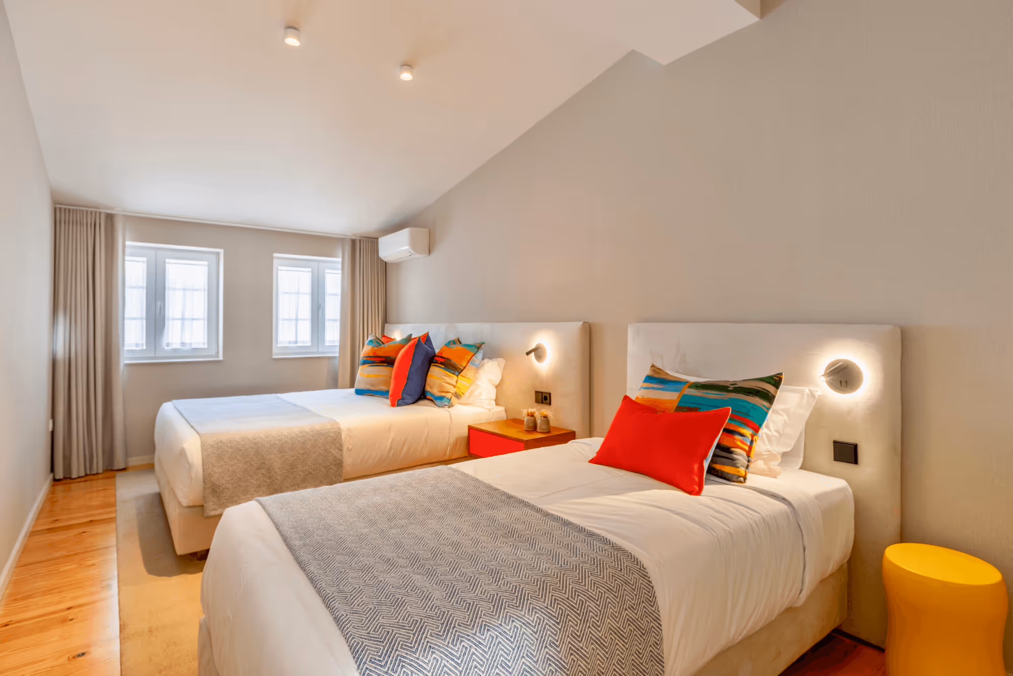 Bedroom with two beds with colorful pillows.