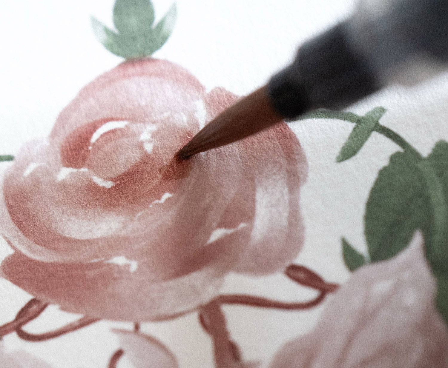 Gros plan sur un pinceau appliquant de l’aquarelle rose pour peindre une fleur, illustration délicate et poétique.