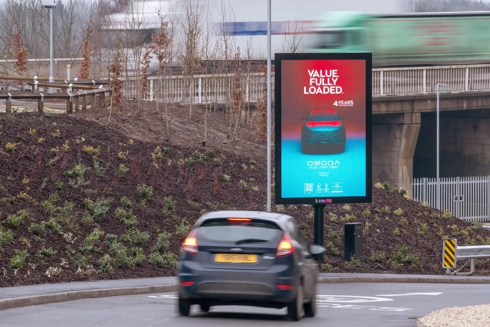 A digital screen showing an Omoda advertisement at the roadside