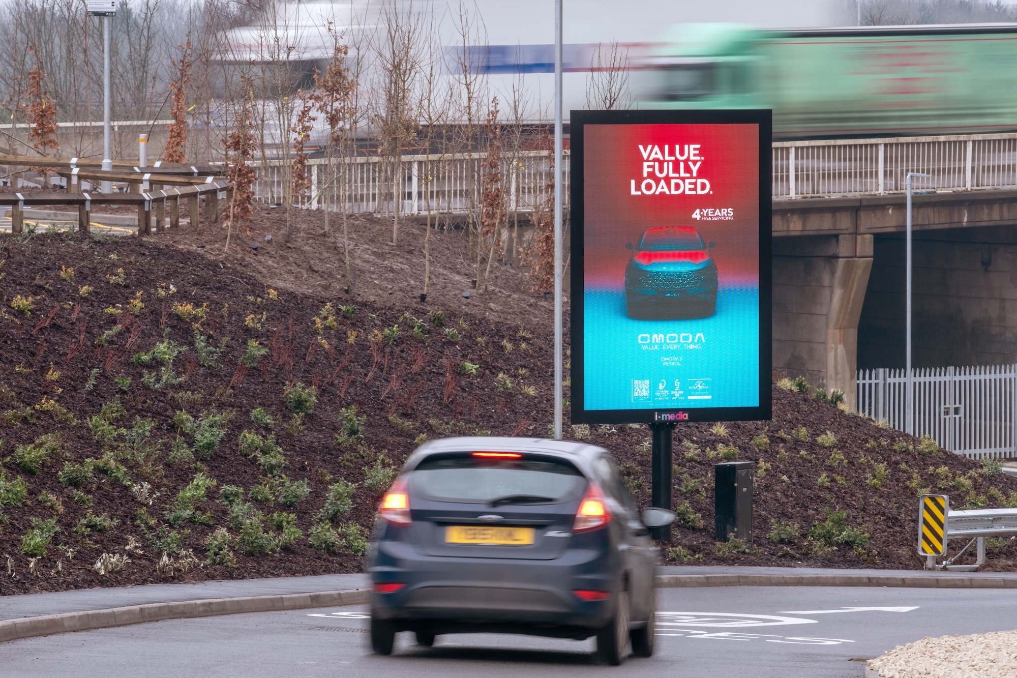 A digital screen showing an Omoda advertisement at the roadside