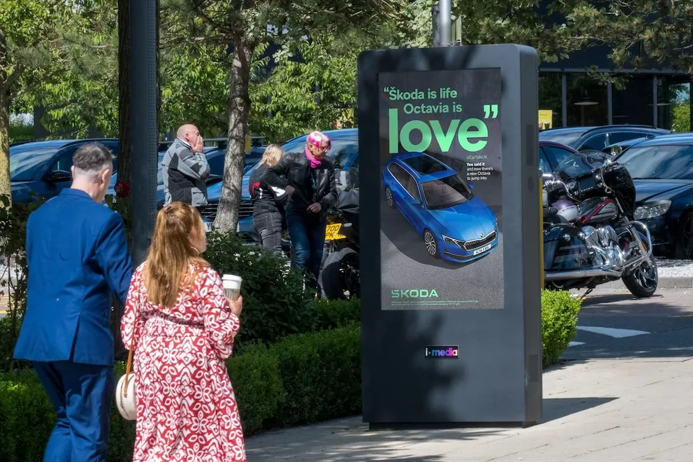 A digital screen showing a Skoda Octavia advert at a motorway services