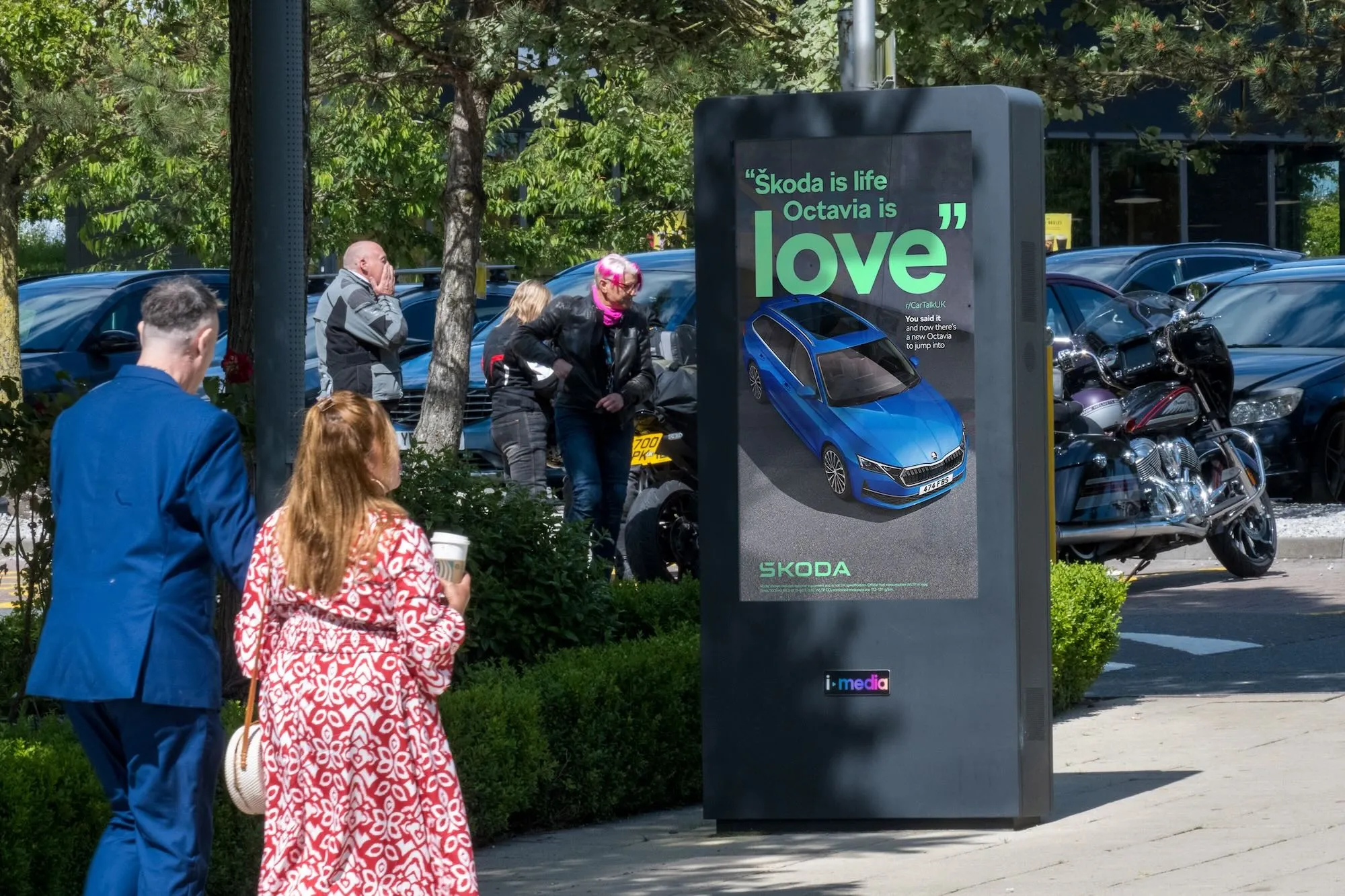 A digital screen showing a Skoda Octavia advert at a motorway services
