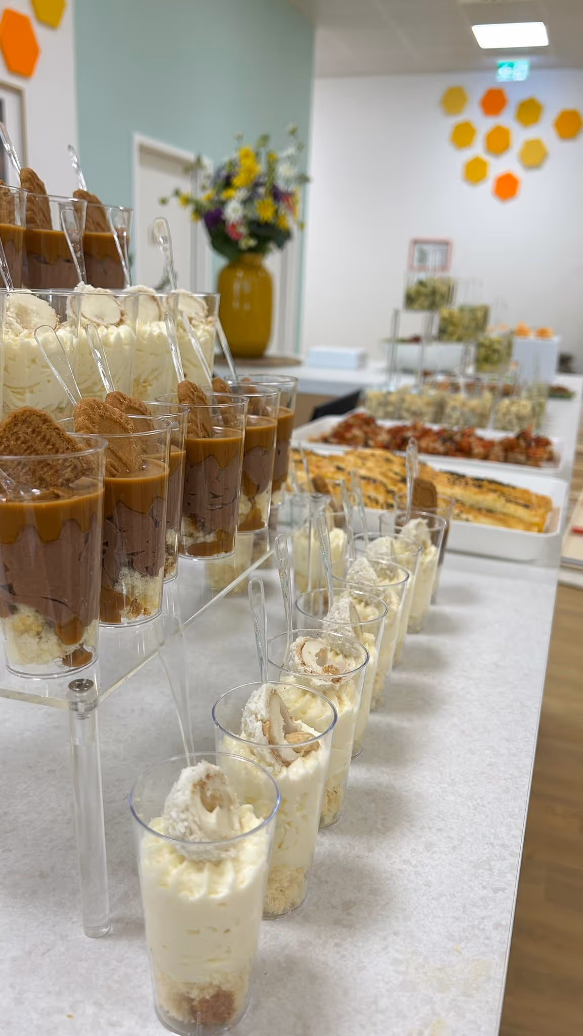 Ein Buffet mit verschiedenen Desserts in Gläsern, darunter Schoko- und Vanillecreme mit Keksen.