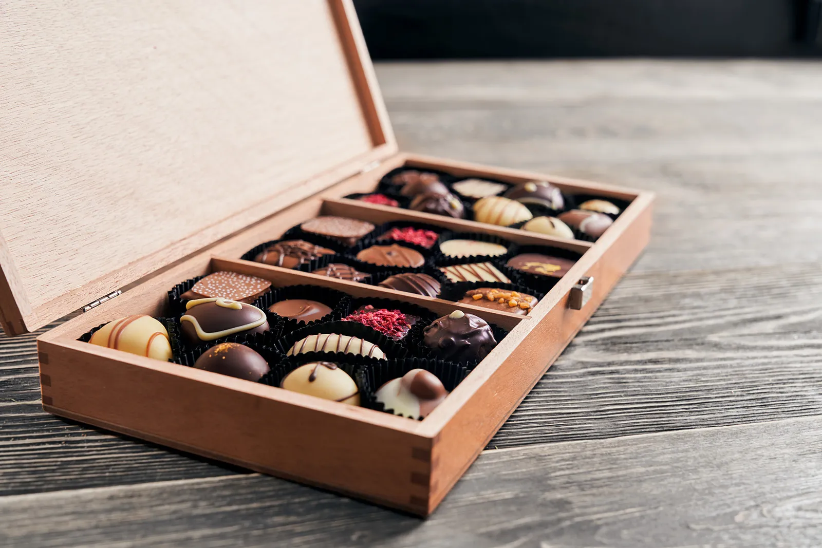 Assortment of chocolates in wooden box.