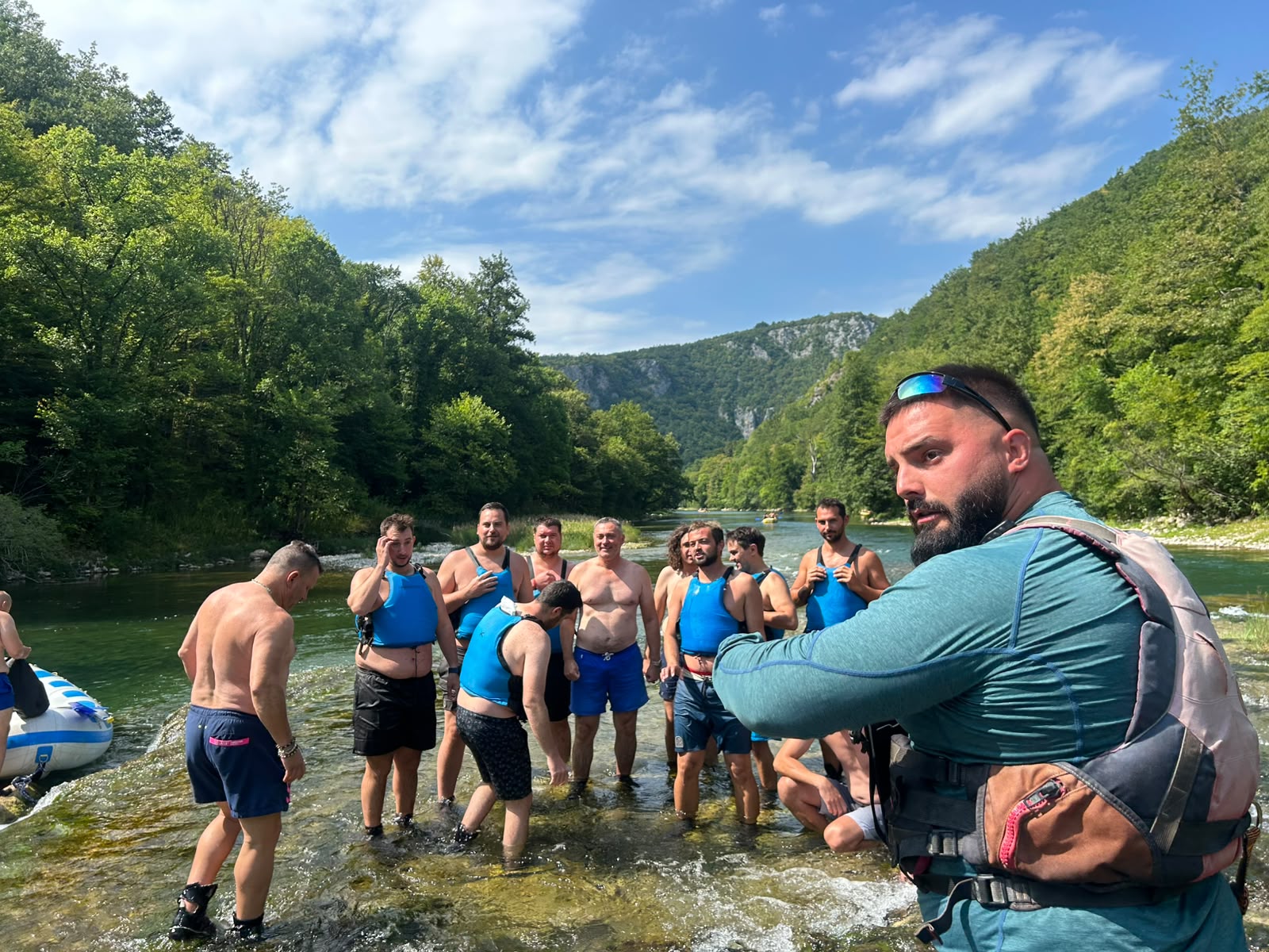 Grupa stoji u plitkoj vodi, skiper u prvom planu