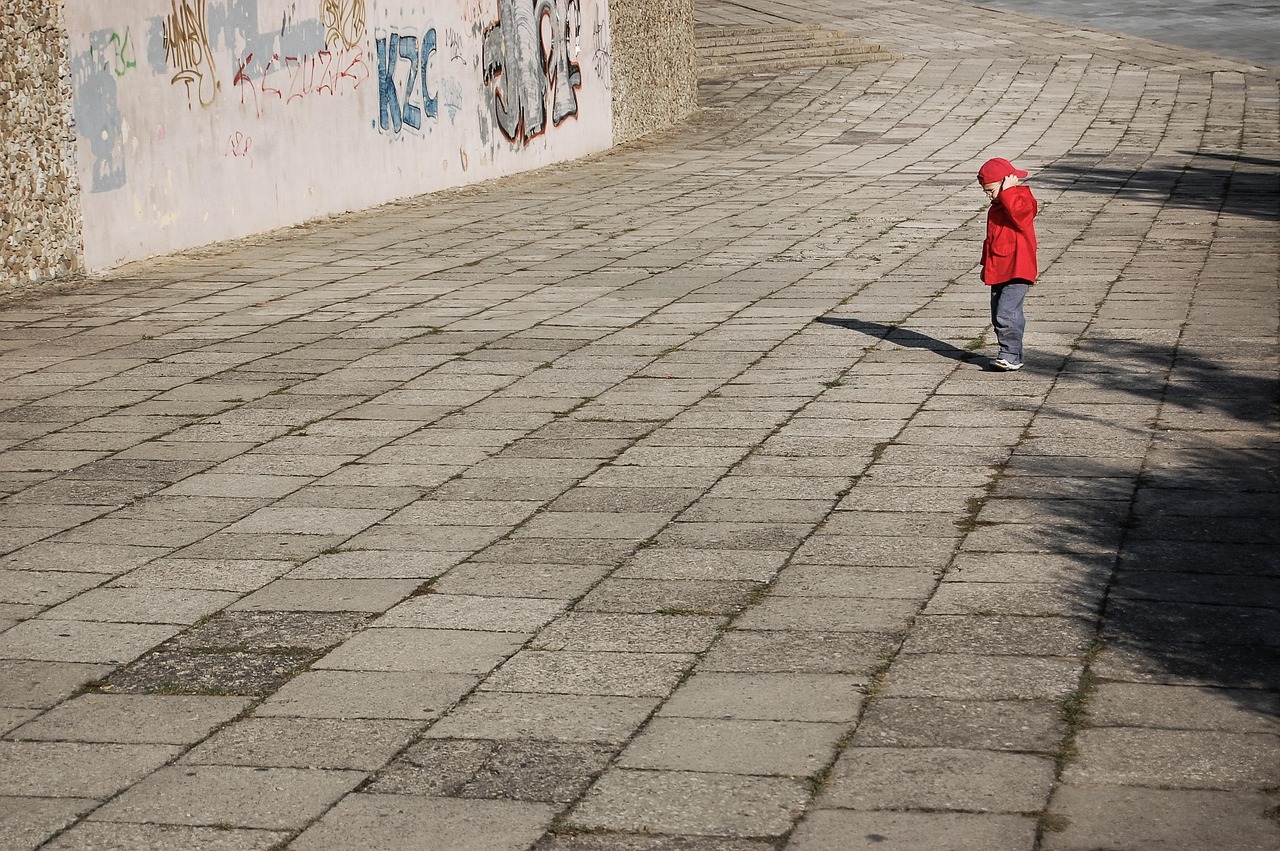 Boy standing alone scratching his head