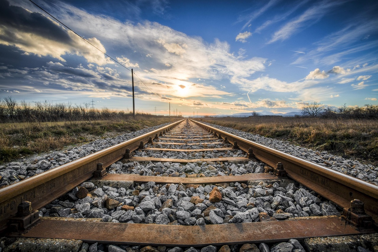 A symmetrical view of railway tracks stretching into the distance under a wide sky