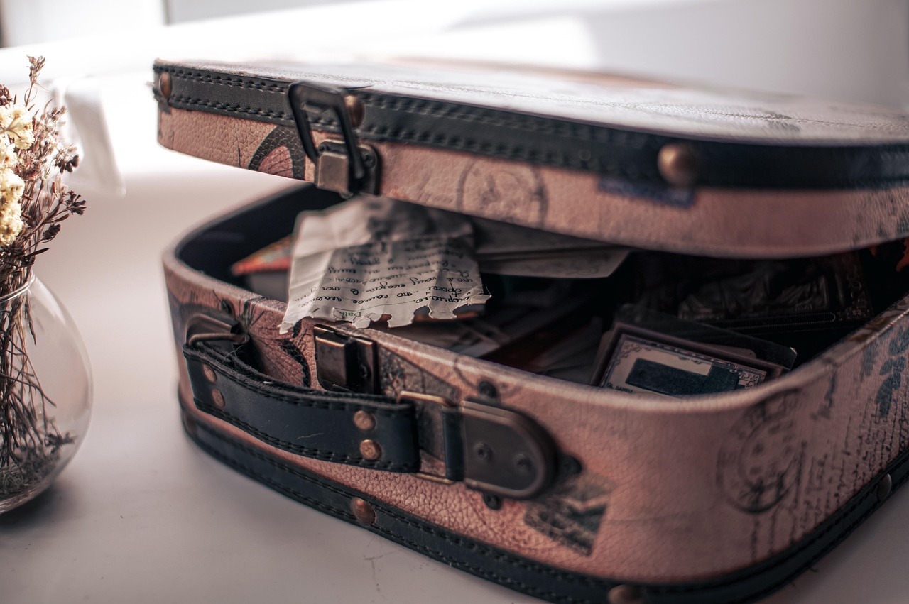 An old suitcase sitting slightly open, with papers and personal items inside