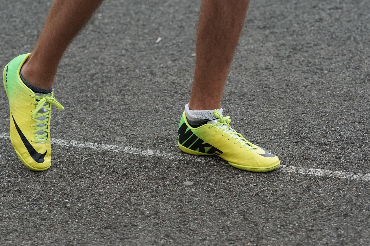 Close-up of a runner’s feet in bright yellow trainers standing on a road