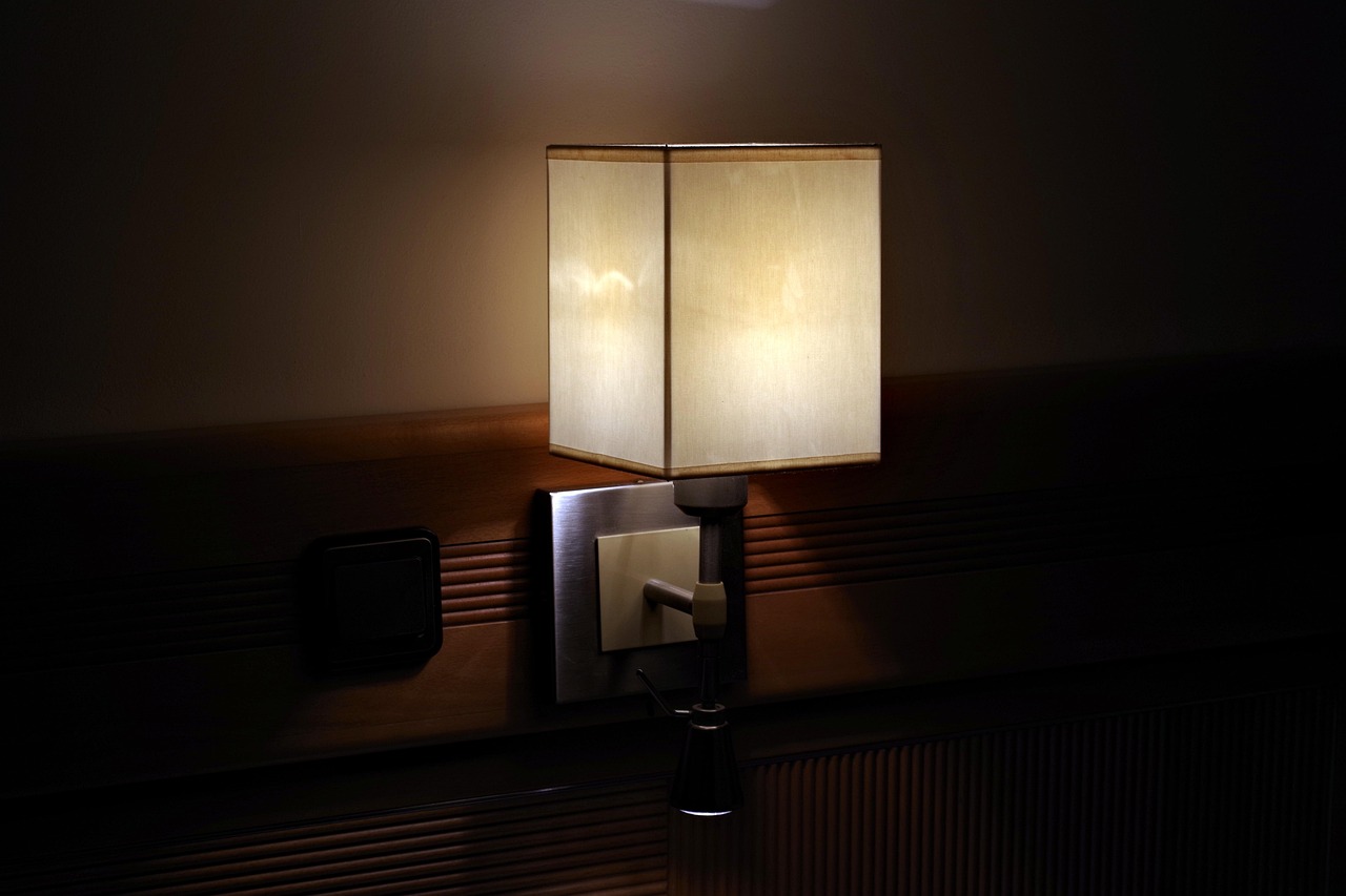 A bedside lamp glowing in a dark room