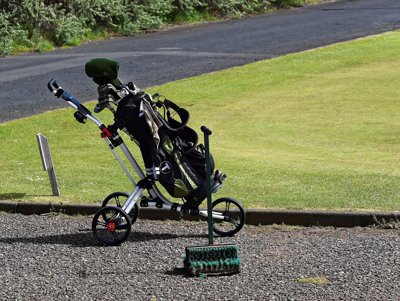 A golf bag and trolley beside the course, representing familiar habits that keep going because they have always been there