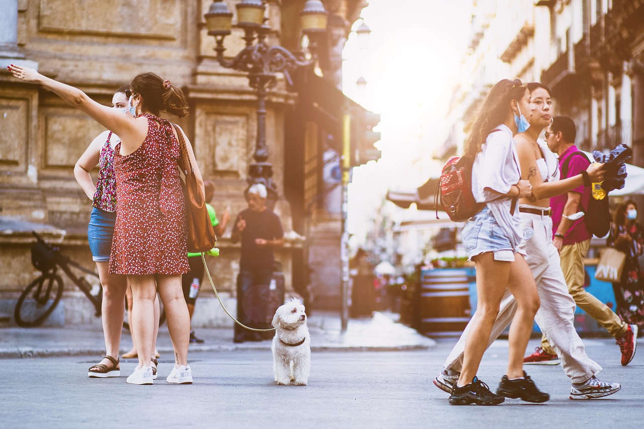People gathered and walking through a busy city street, representing the original meaning of vulgar as ordinary or common