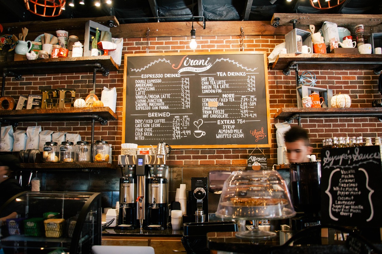 A coffee shop menu board with prices behind the counter, representing how everyday costs rise over time