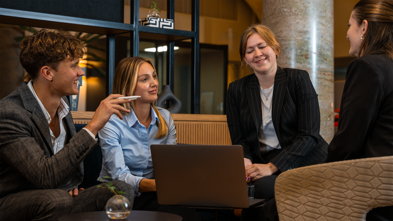 Four CEMAsys employees sitting in circle with a computer in front of them while chatting